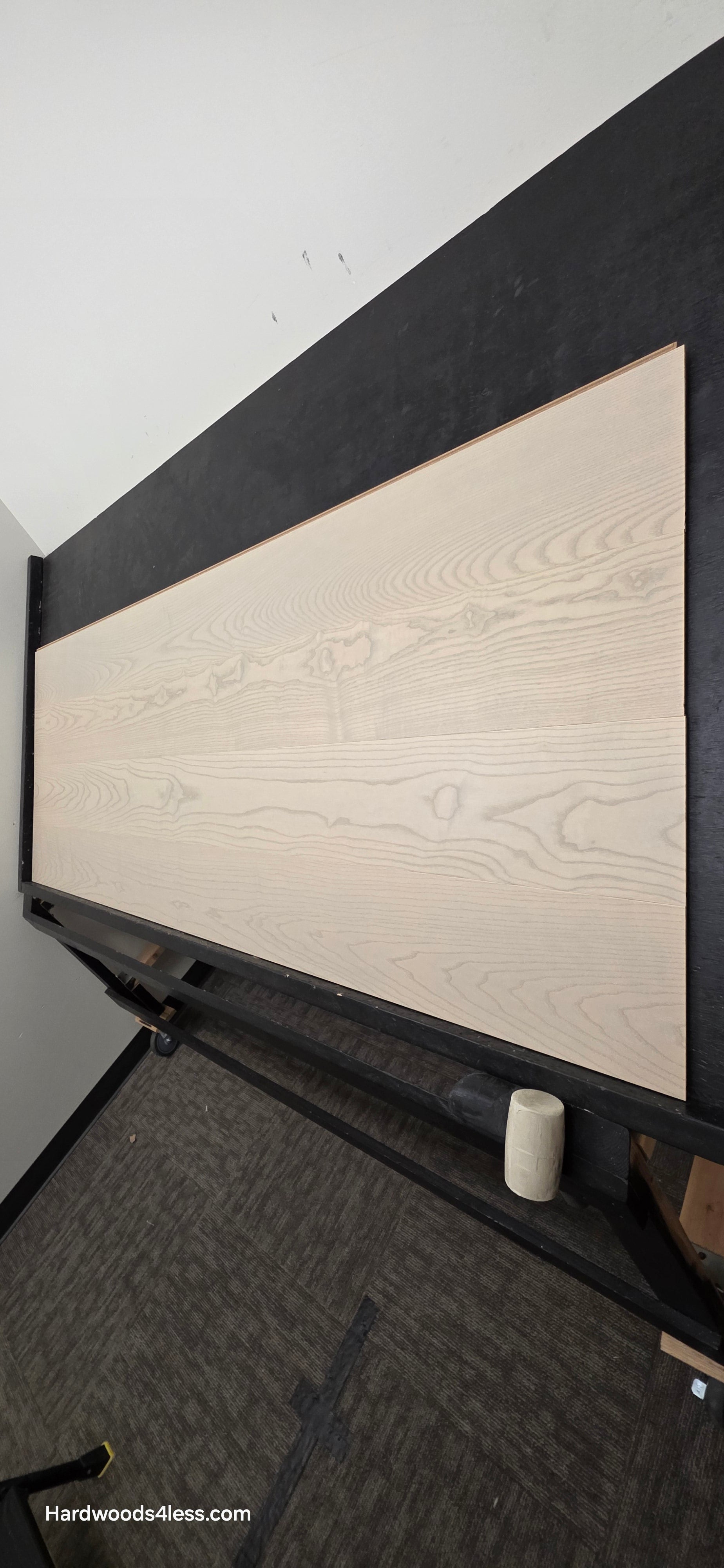 8.11" x 7/16" Modernized Engineered Ash Foster Hardened Hardwood Flooring. Shown on a black shooting table. Shot from steep right.
