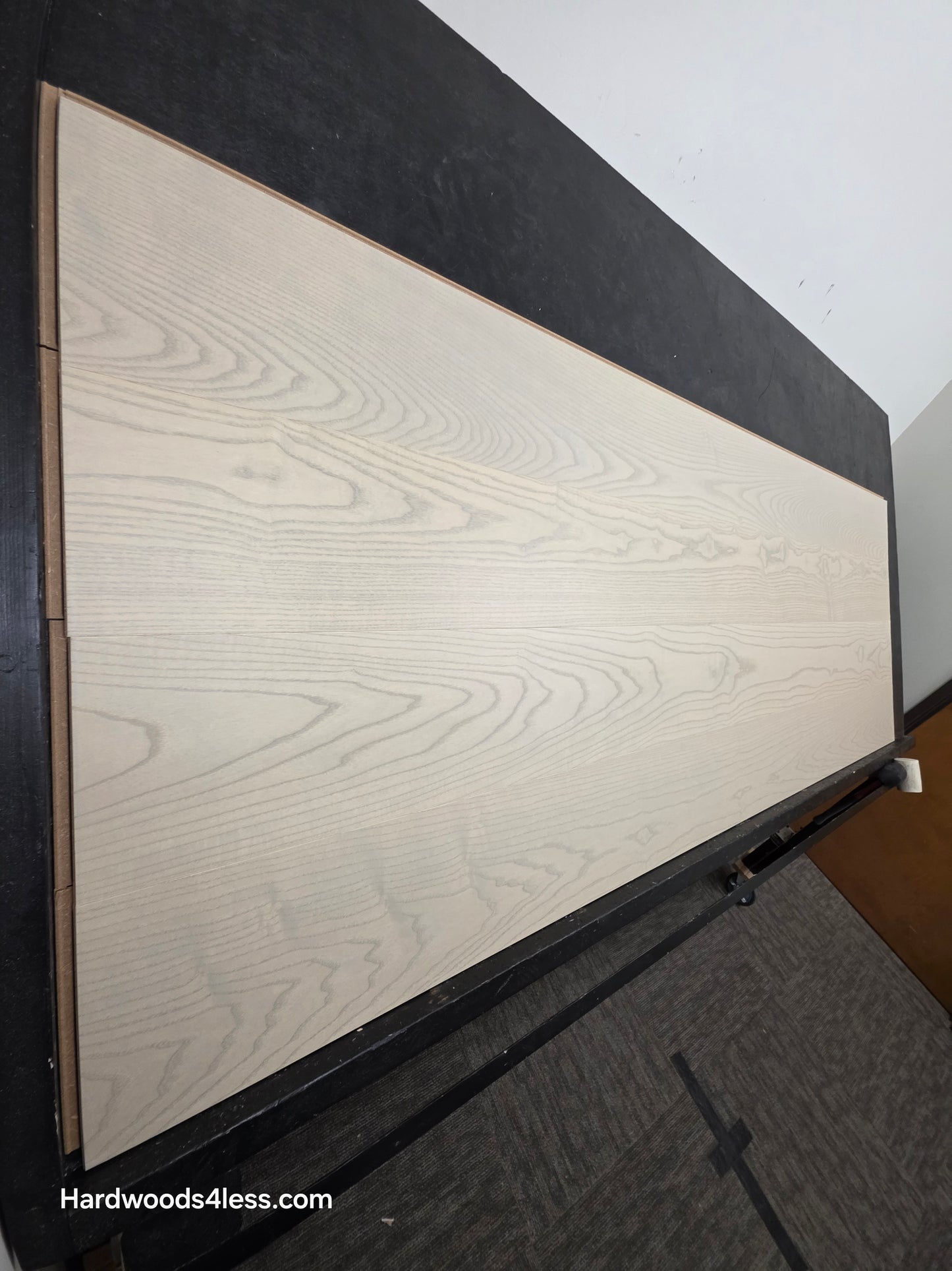 8.11" x 7/16" Modernized Engineered Ash Foster Hardened Hardwood Flooring. Shown on a black shooting table. Shot from steep left. 