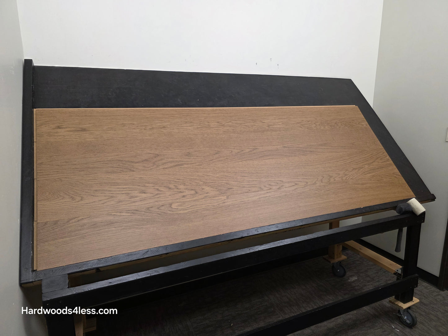 8.11" x 7/16" Modernized Engineered European Oak Calatrava Hardened Hardwood Flooring. Shown on a black shooting table. Shot from wide left.