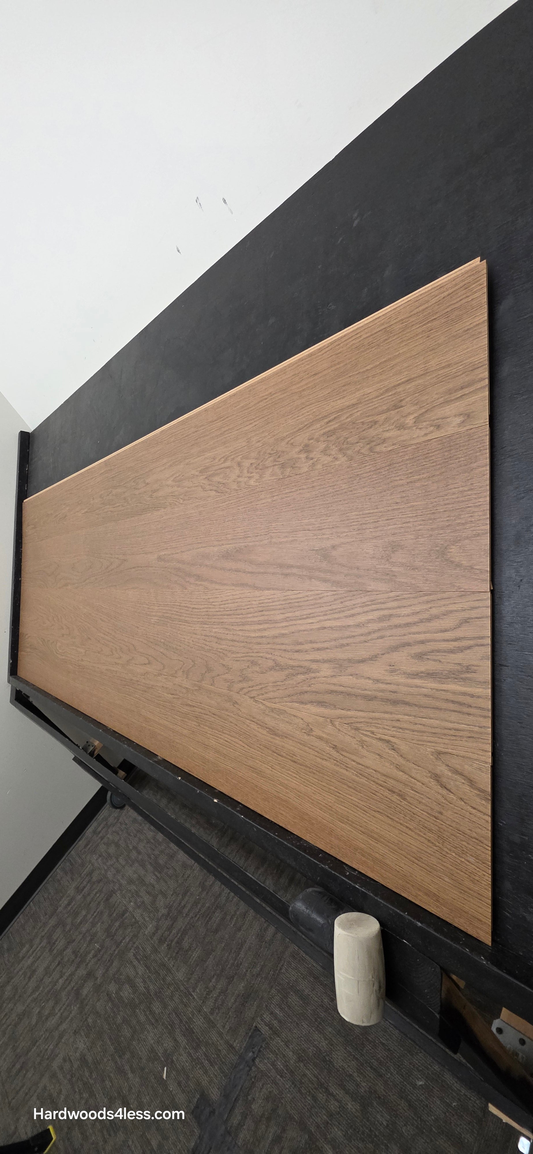 8.11" x 7/16" Modernized Engineered European Oak Calatrava Hardened Hardwood Flooring. Shown on a black shooting table. Shot from steep right.