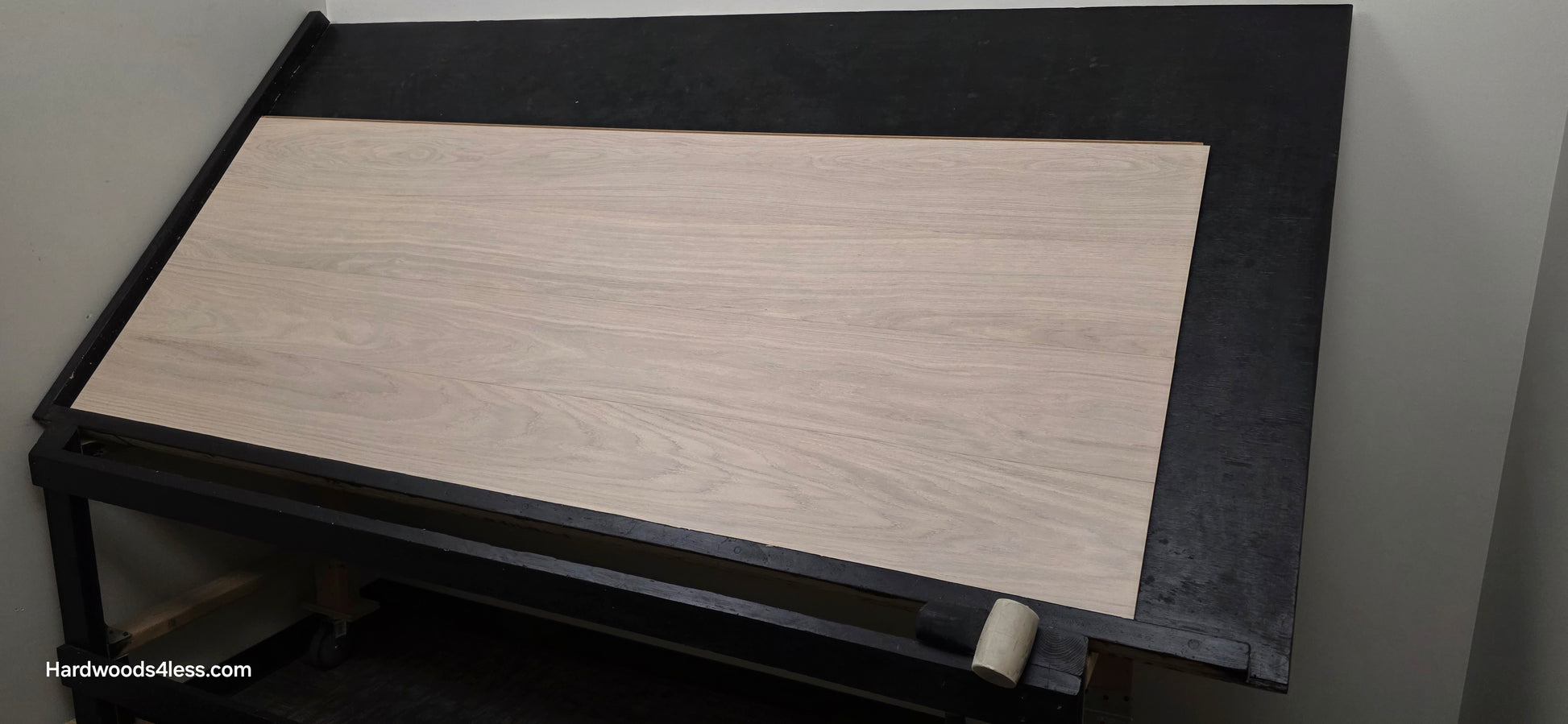 8.11 x 716 Modernized Engineered European Oak Corbusier hardened Hardwood Flooring. Shown on a black shooting table. Shot from wide right. Darkened to show the grain.