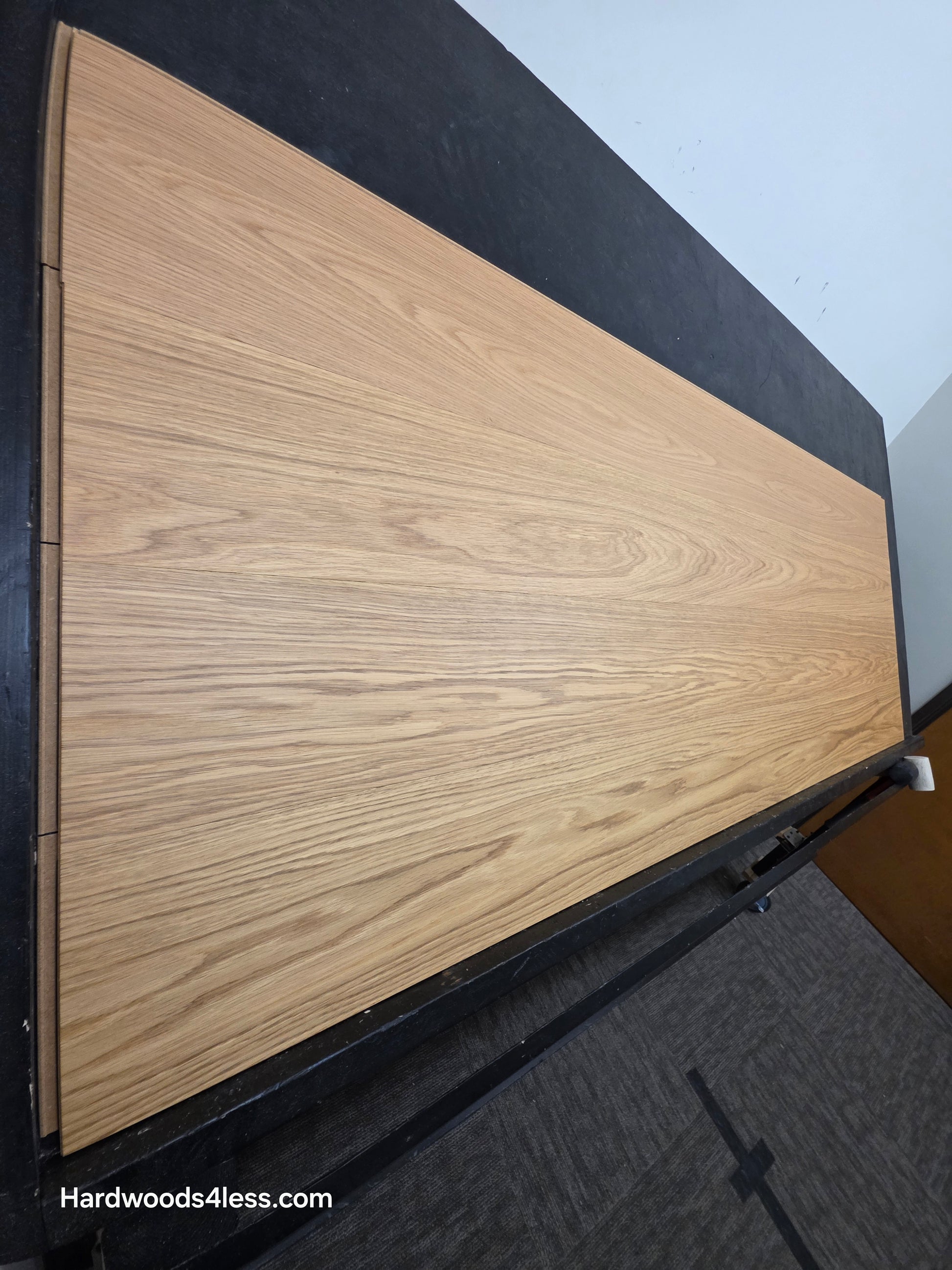8.11" x 7/16" Modernized Engineered European Oak Hadid Hardened Hardwood Flooring. Shown on a black shooting table. Shot from steep left. 
