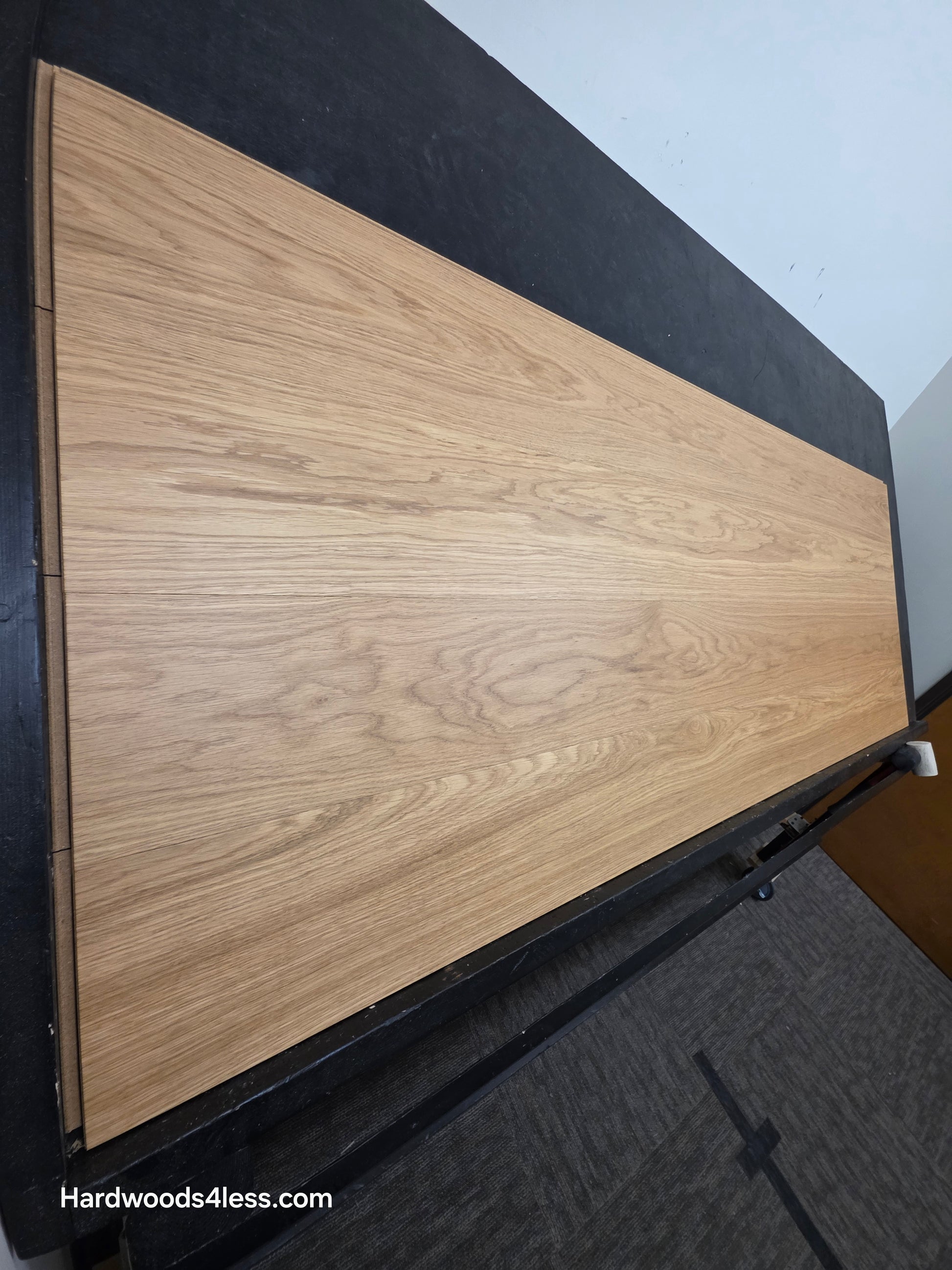 8.11" x 7/16" Modernized Engineered European Oak Wright Hardened Hardwood Flooring. Shown on a black shooting table. Shot from steep left.