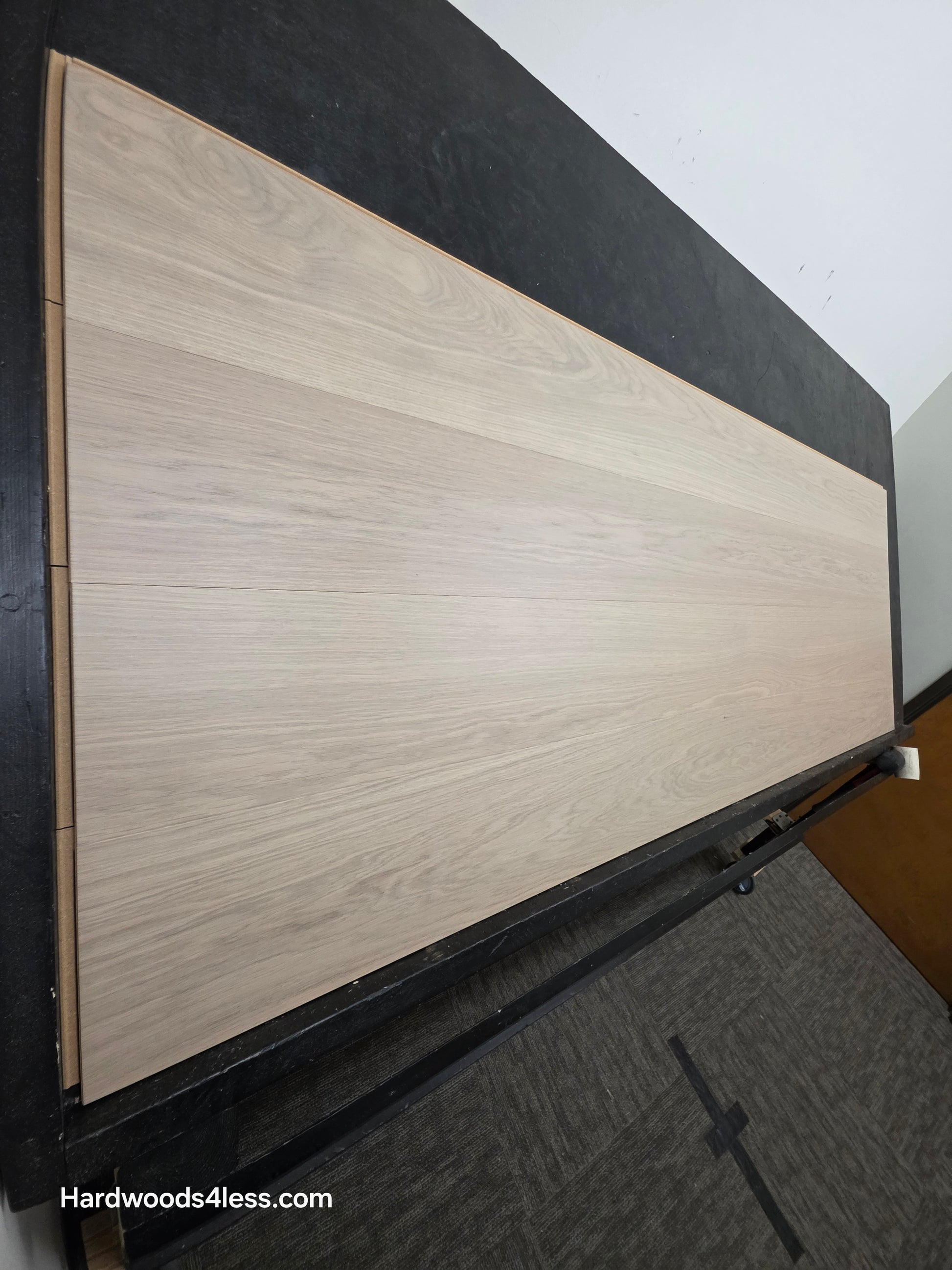 8.11" x 7/16" Modernized Engineered European Oak Foster Hardened Hardwood Flooring. Shown on a black shooting table. Shot from steep left.