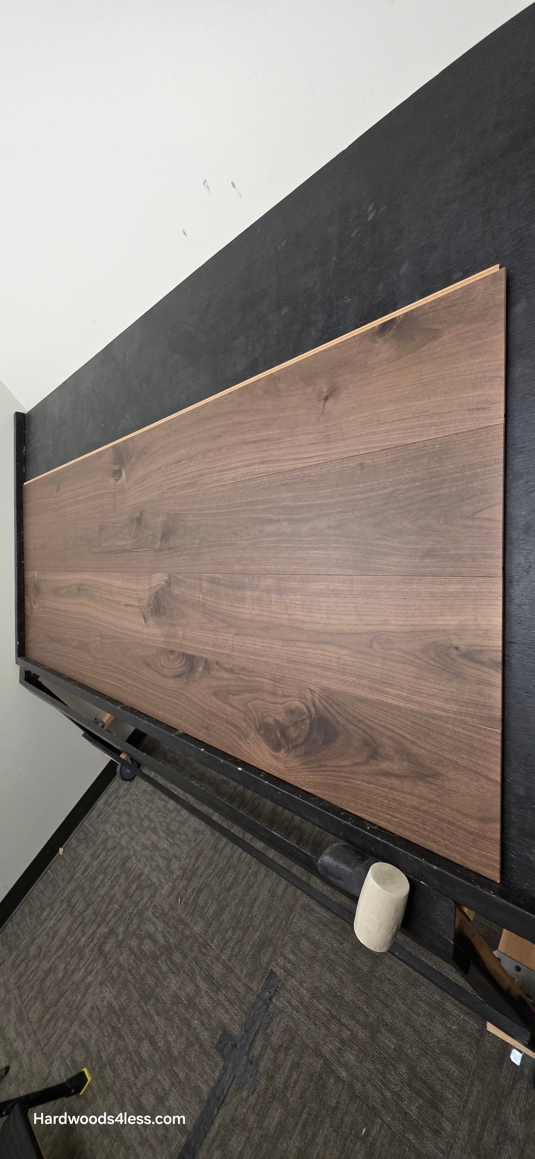 8.11" x 7/16" Modernized Engineered Walnut Calatrava Hardened Hardwood Flooring. Shown on a black shooting table. Shot from wide right.