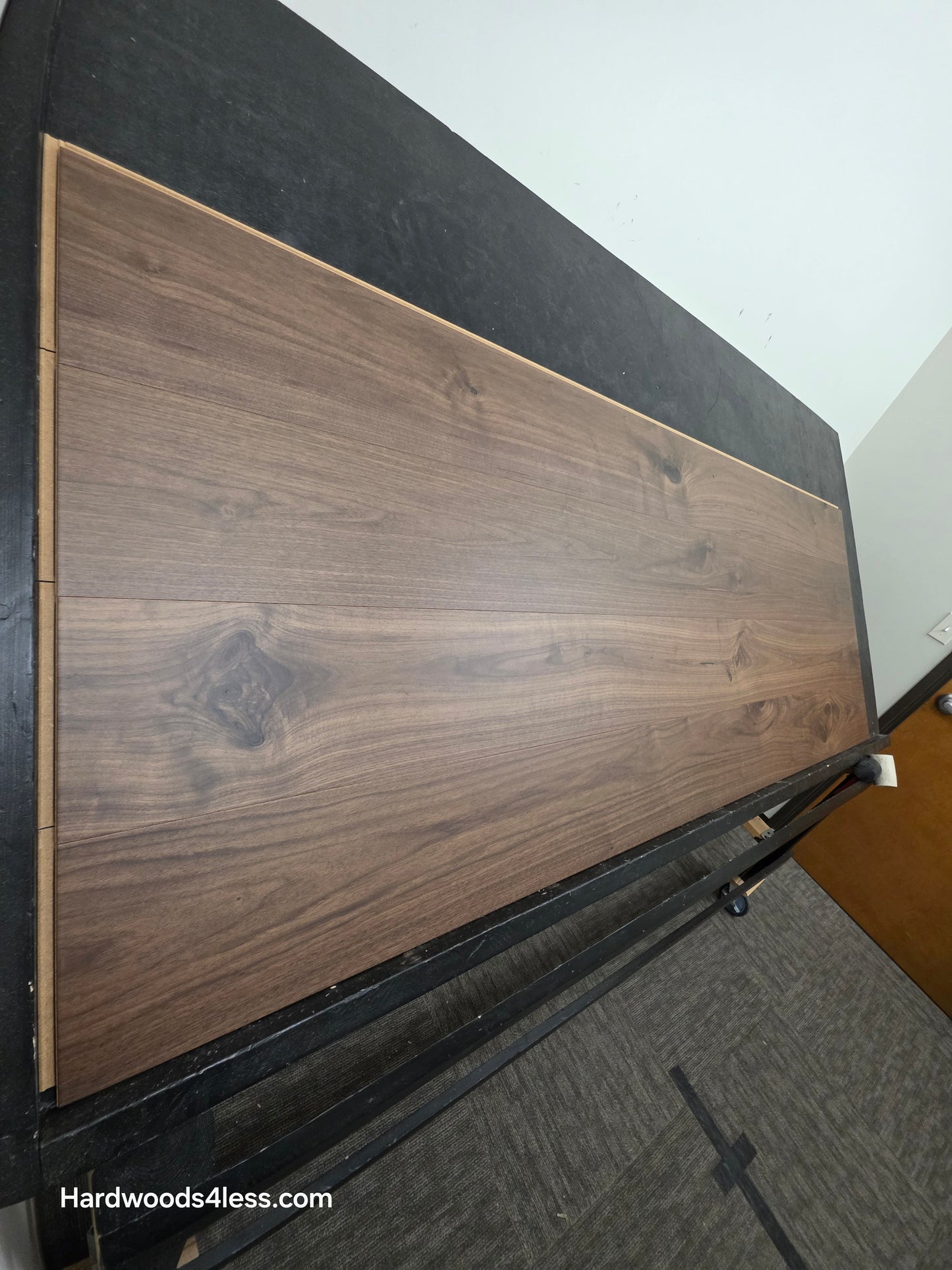 8.11" x 7/16" Modernized Engineered Walnut Calatrava Hardened Hardwood Flooring. Shown on a black shooting table. Shot from steep left. 