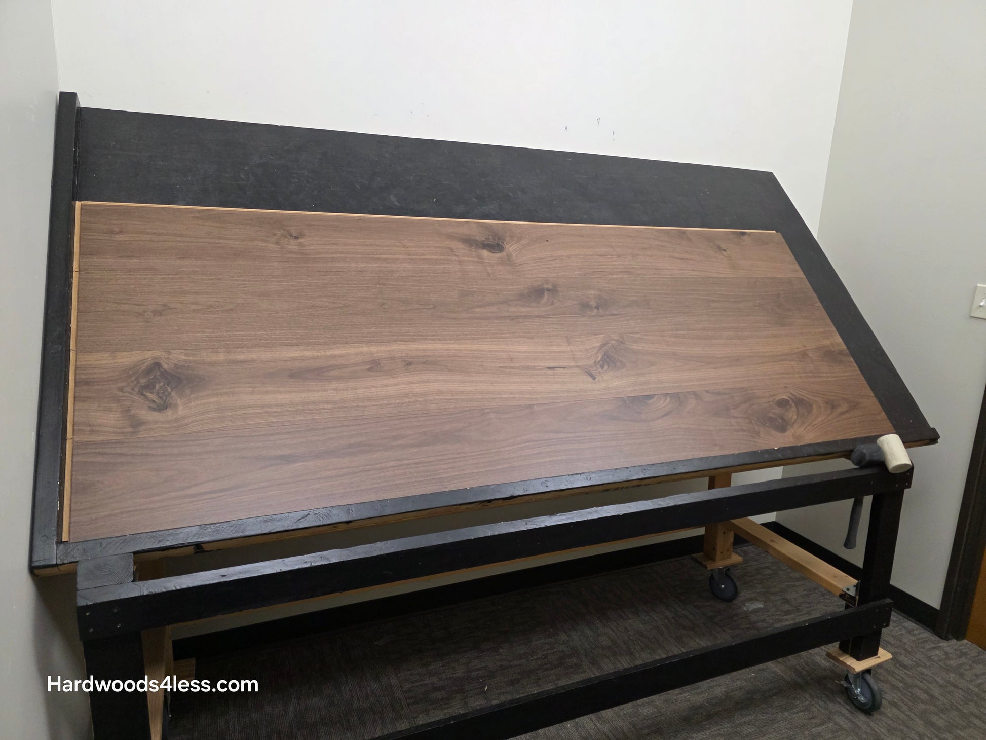 8.11" x 7/16" Modernized Engineered Walnut Calatrava Hardened Hardwood Flooring. Shown on a black shooting table. Shot from wide left. 