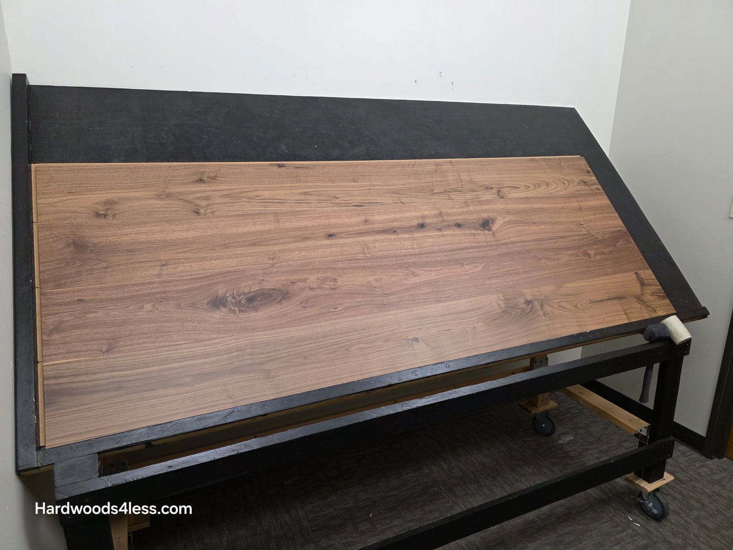 8.11" x 7/16" Modernized Engineered Walnut Wright Hardened Hardwood Flooring. Shown on a black shooting table. Shot from wide left.