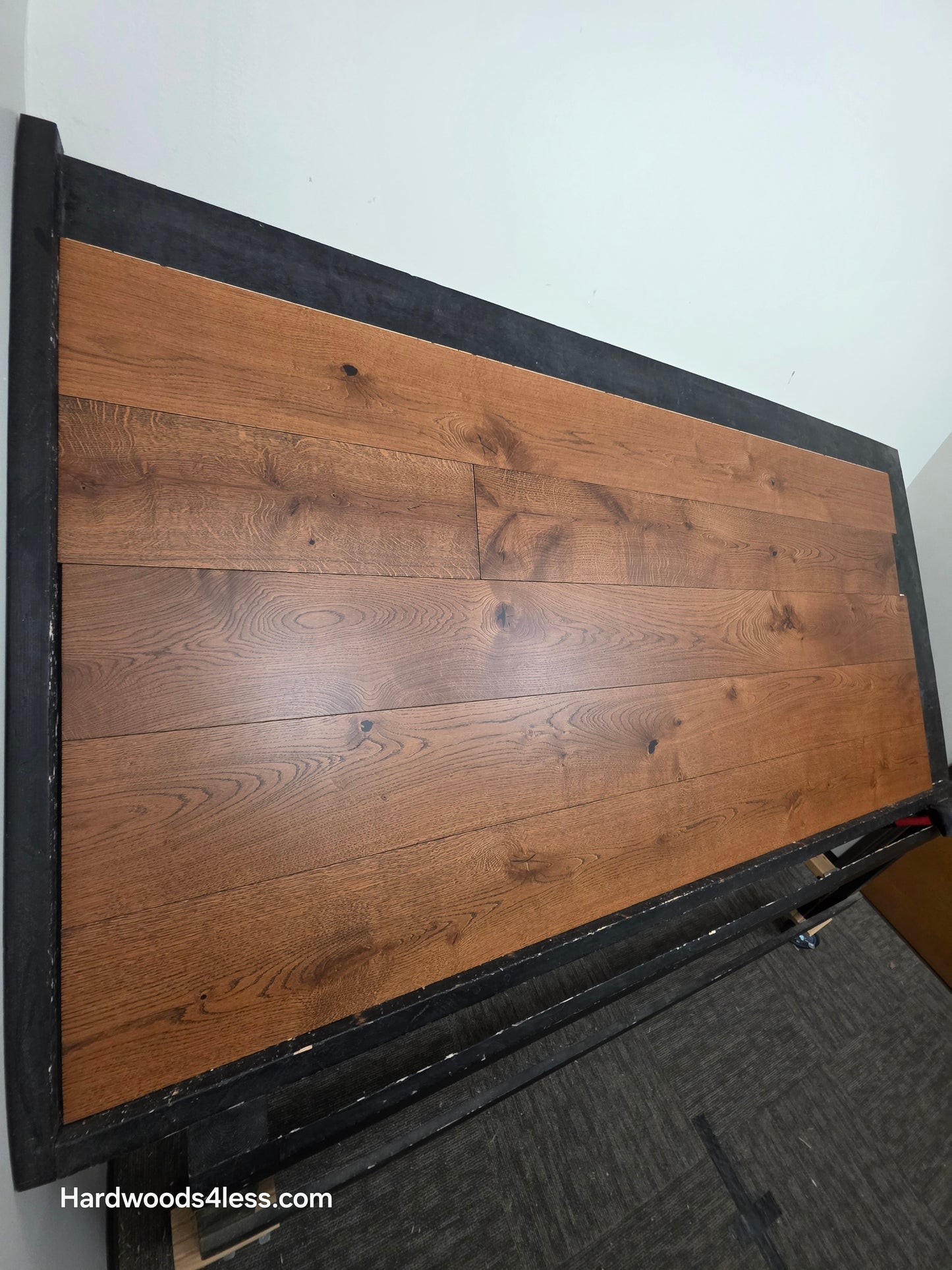 8 1/4" x 9/16" Engineered European Oak Corinth Hardwood Flooring. Shown on a black shooting rack. Shot wide left.