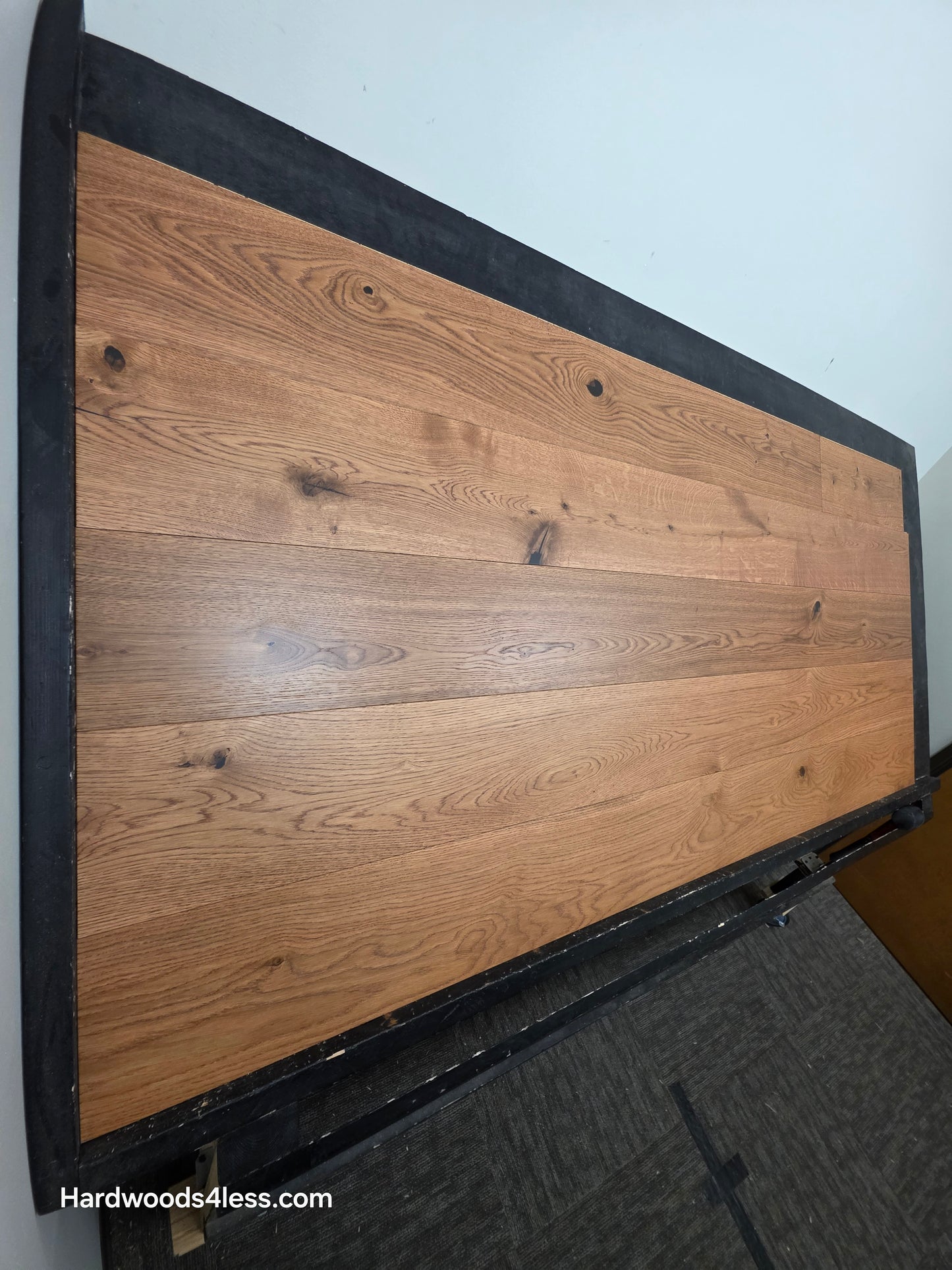 8 1/4" x 9/16" Engineered European Oak Helios Hardwood Flooring. Shown on a black shooting table. Steep left angle shot. 