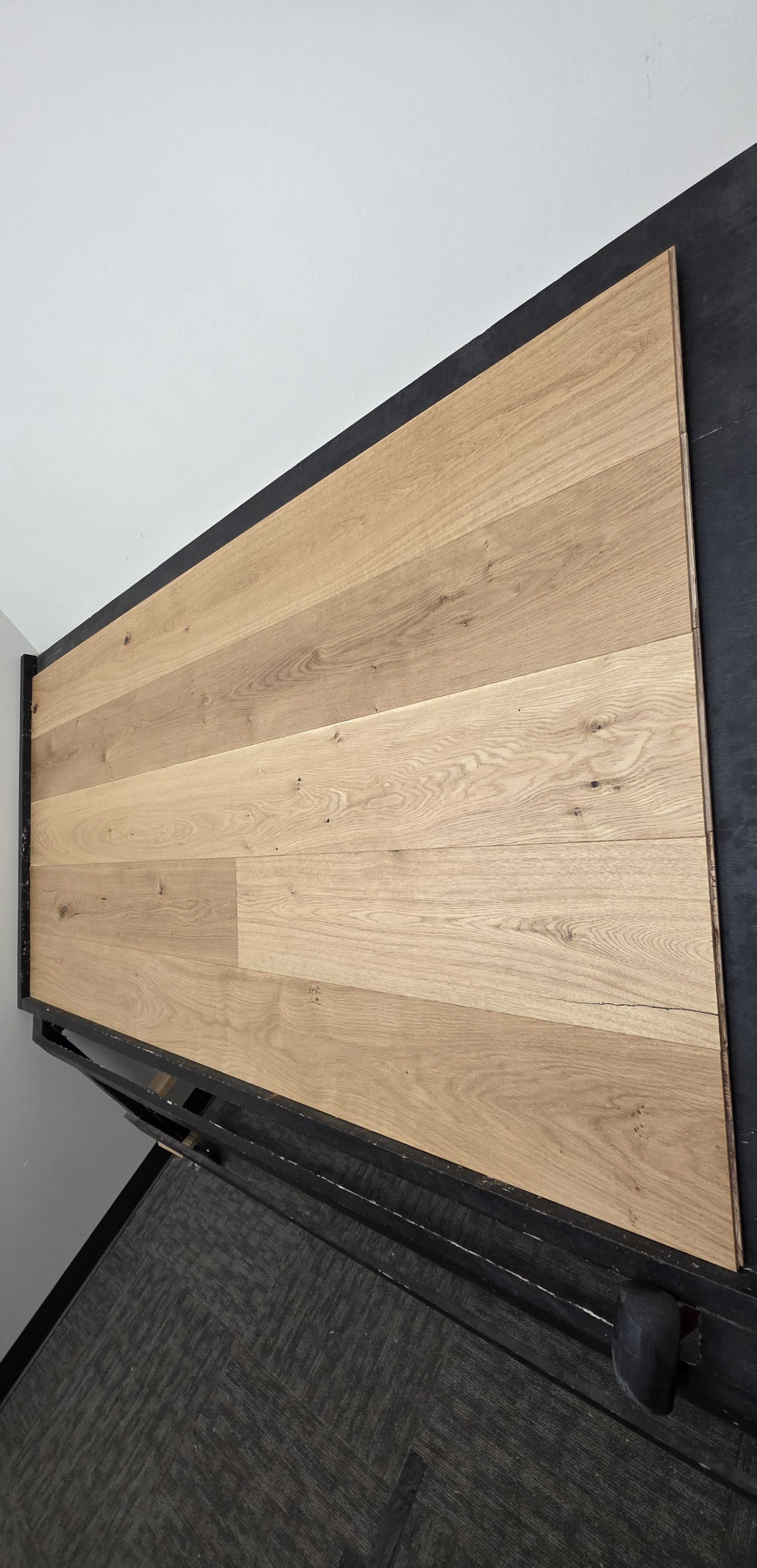 8 5/8" x 5/8" Engineered European Oak Buckwheat Hardwood Flooring shown on a black shooting table. steep skinny right angle shot
