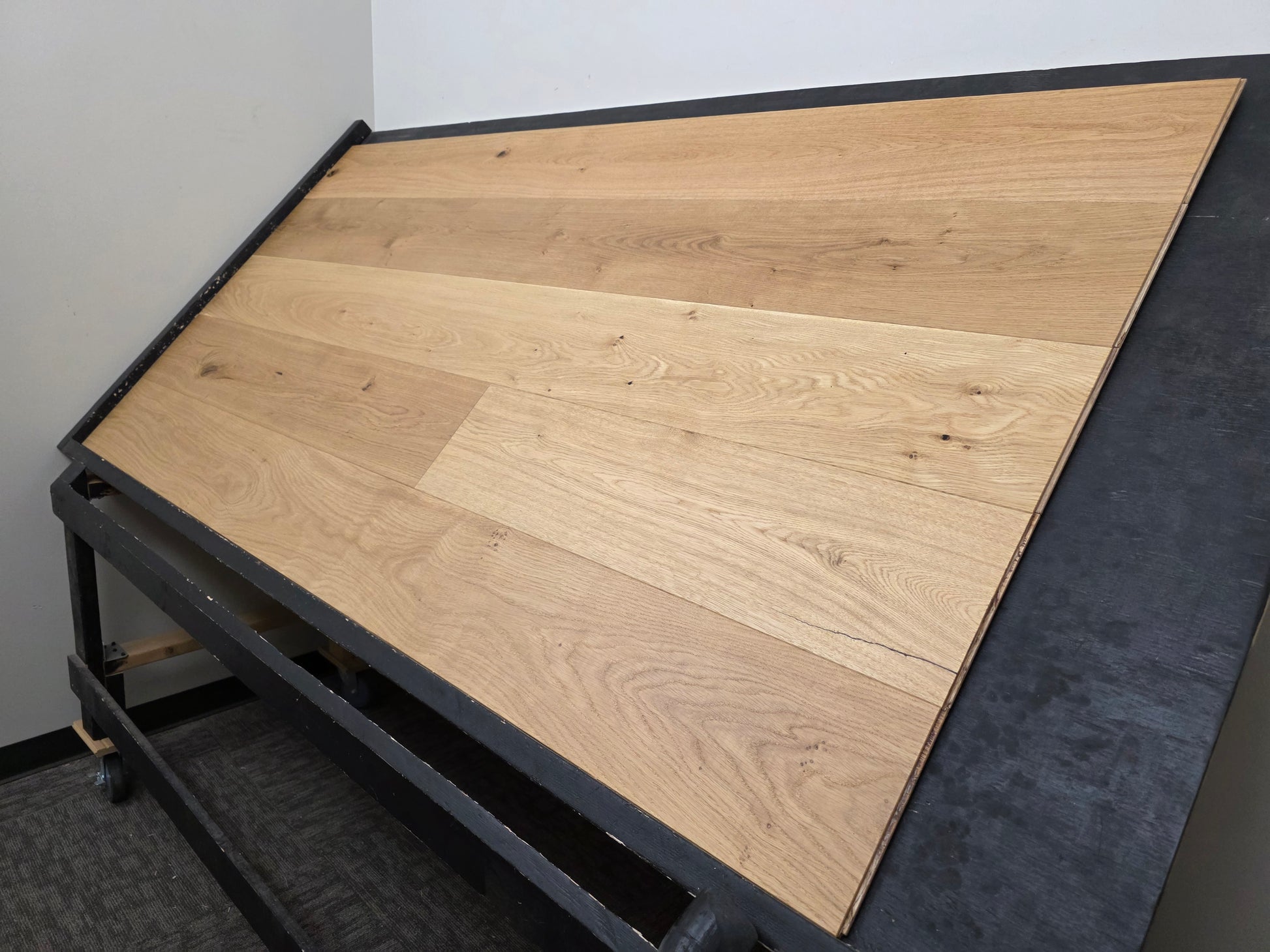 8 5/8" x 5/8" Engineered European Oak Buckwheat Hardwood Flooring shown on a black shooting table. steep right angle shot 