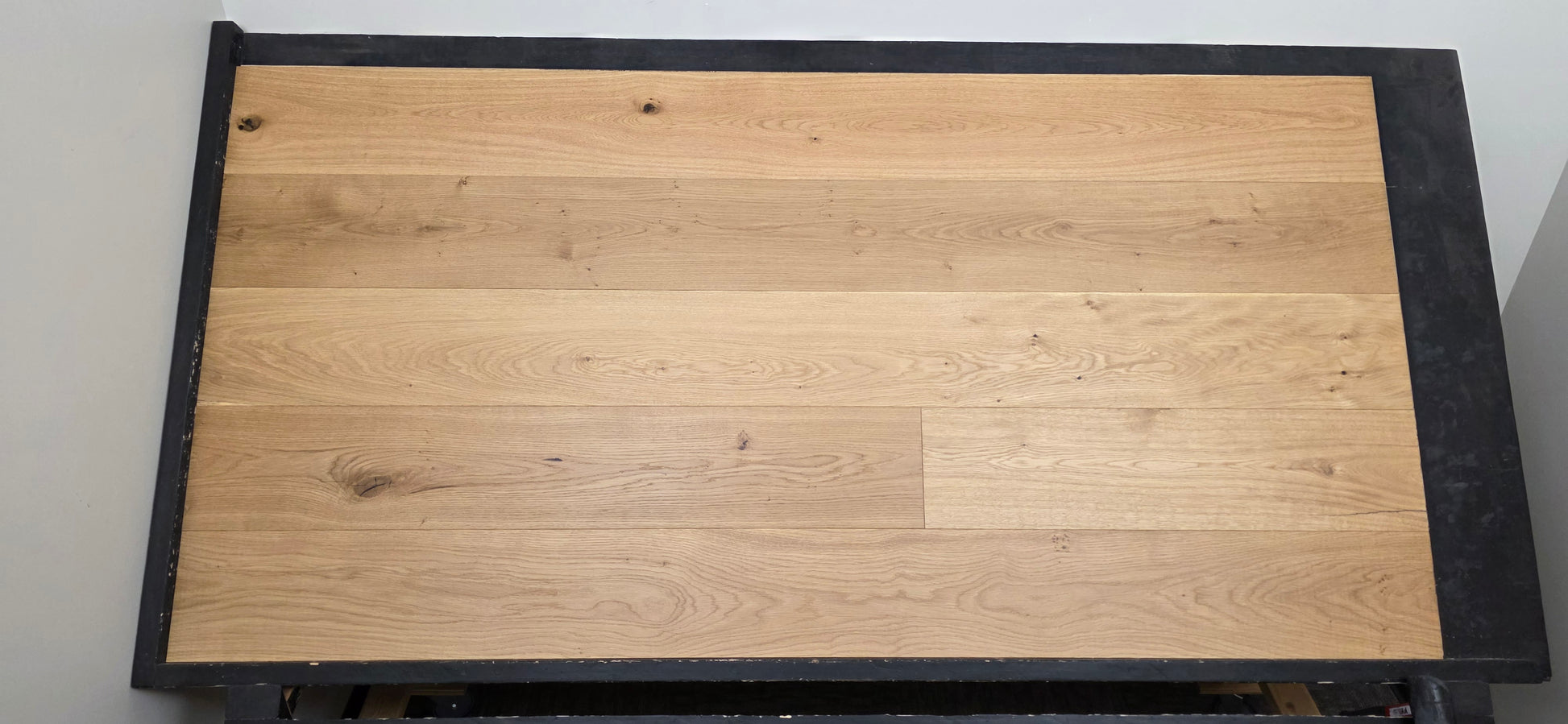 8 5/8" x 5/8" Engineered European Oak Buckwheat Hardwood Flooring shown on a black shooting table. front shot