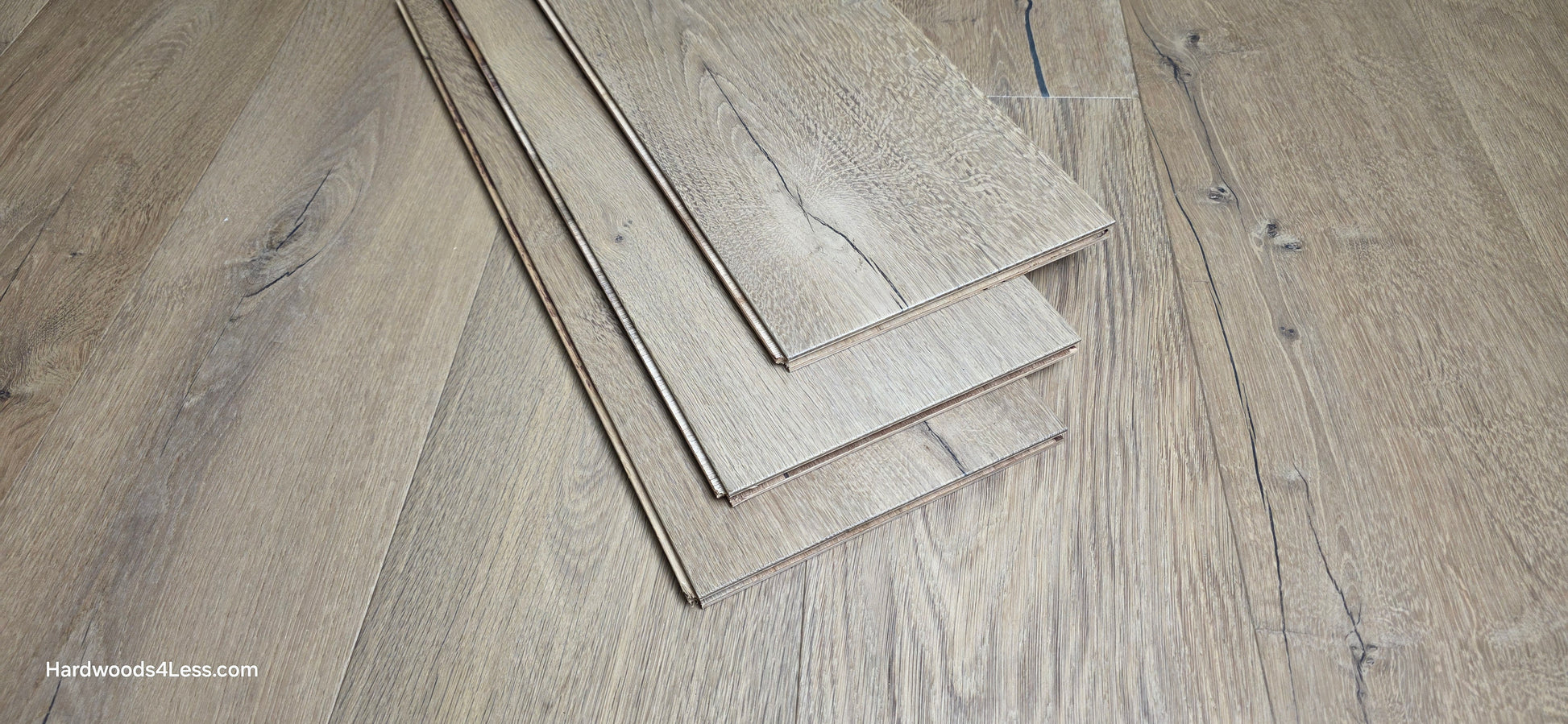 8 5/8" x 5/8" Engineered European Oak Highball Hardwood Flooring. Shown at center are 3 planks of the flooring. The planks are resting on top of the European oak flooring.