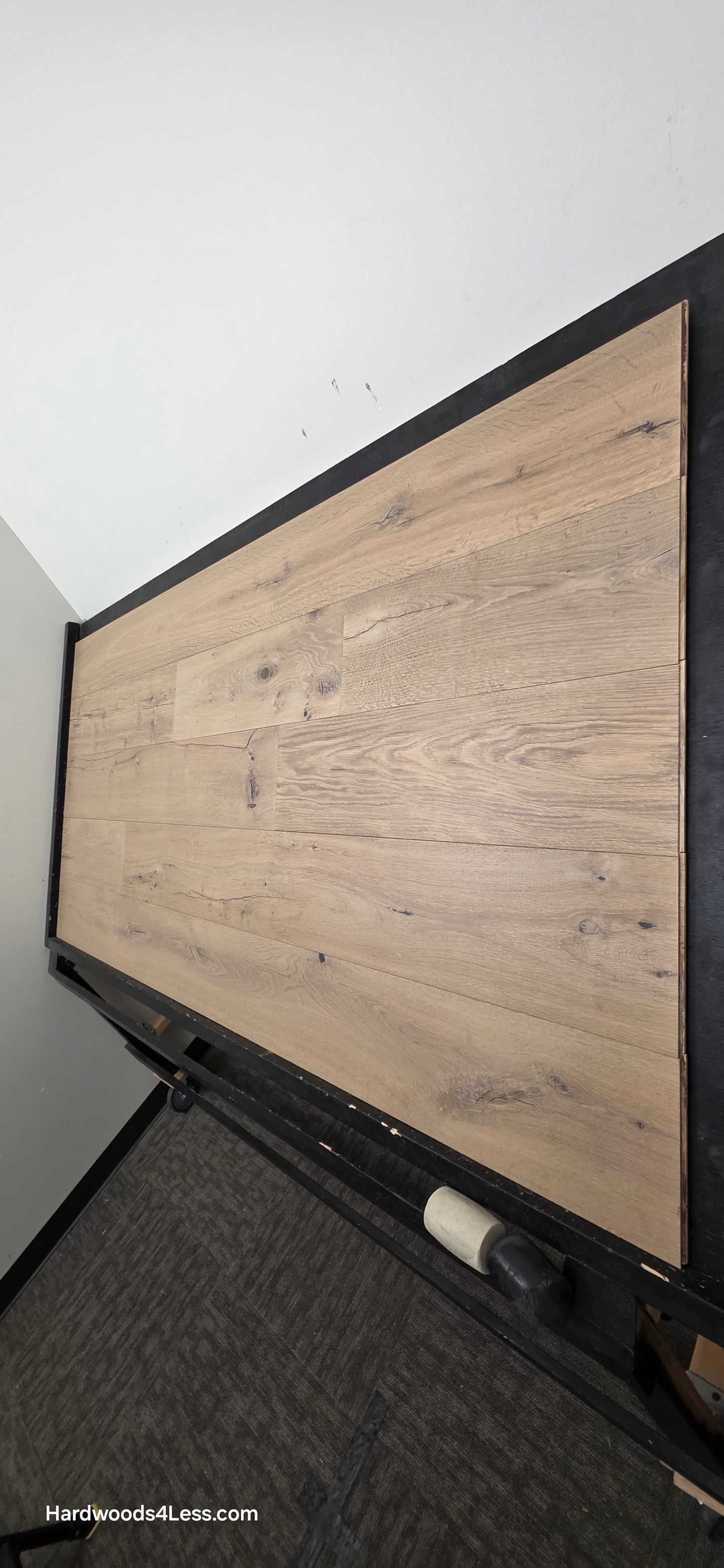 8 5/8" x 5/8" Engineered European Oak Highball Hardwood Flooring. Shown on a black shooting table. Shot from steep right.