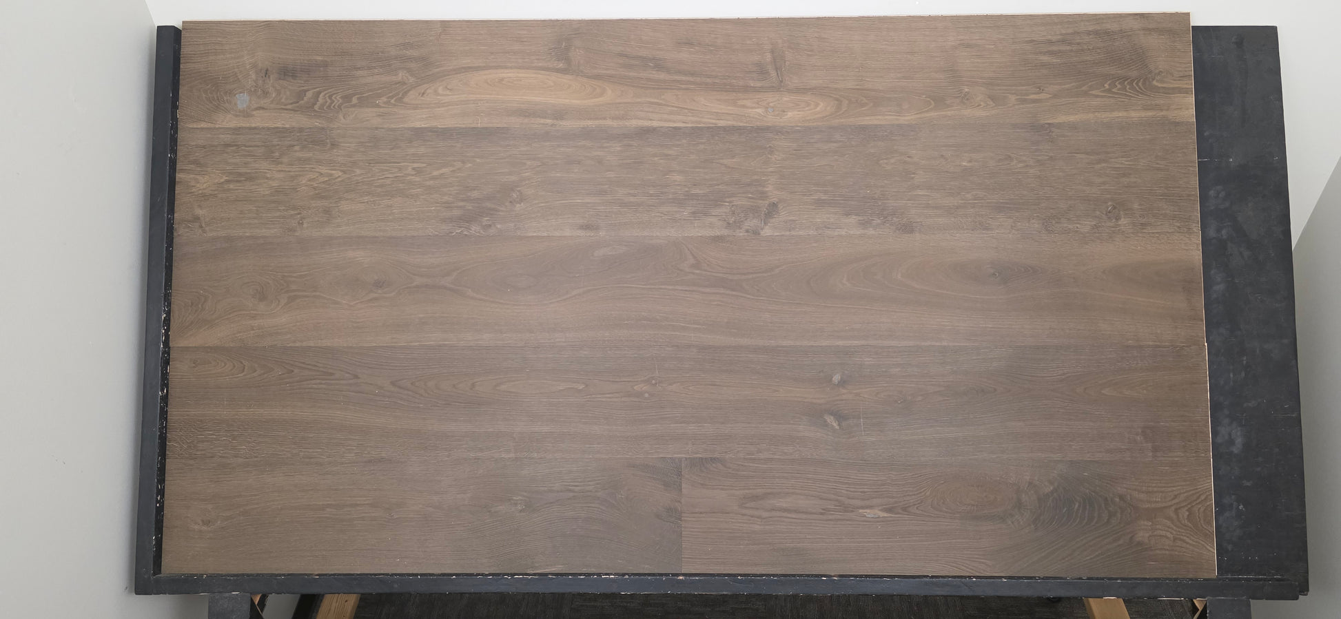 Engineered Unfinished Smoked European Oak Hardwood Flooring on a black table