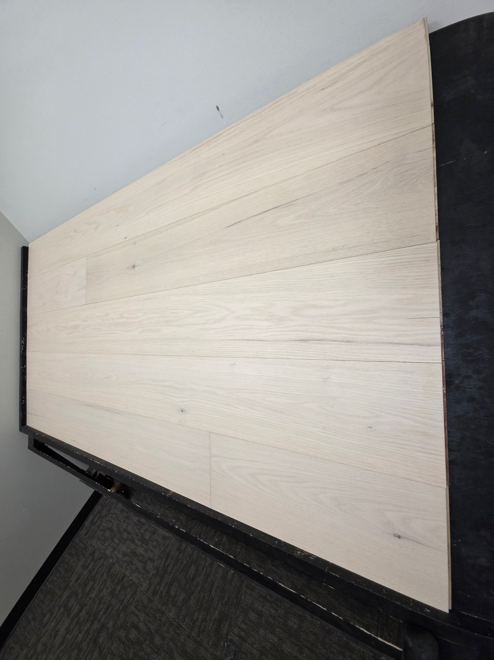 9 1/2" x 5/8" Engineered Red Oak Initium Hardwood Flooring on a black shooting table. steep right side shot