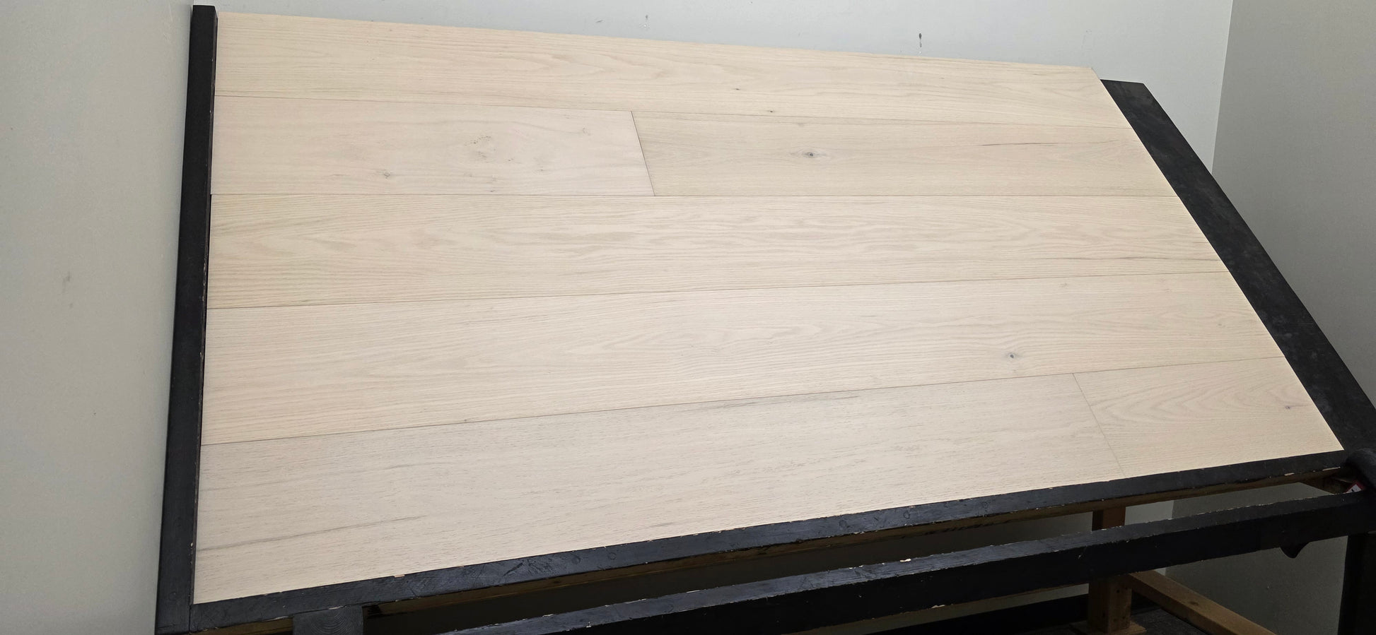 9 1/2" x 5/8" Engineered Red Oak Initium Hardwood Flooring on a black shooting table. Left side shot
