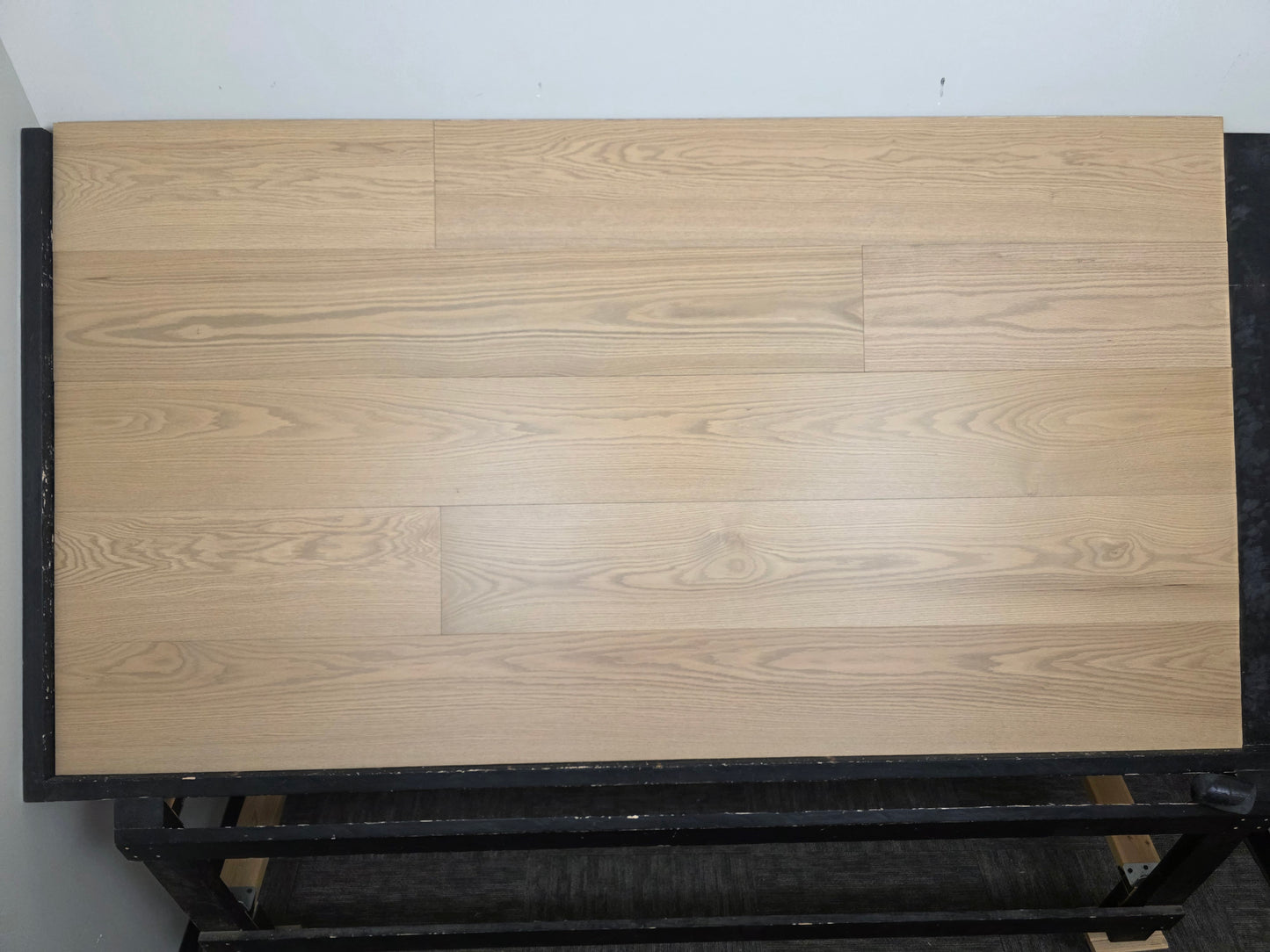 9 1/2" x 5/8" Engineered White Oak Finch Hardwood Flooring. Shown  on a black shooting table head on. 
