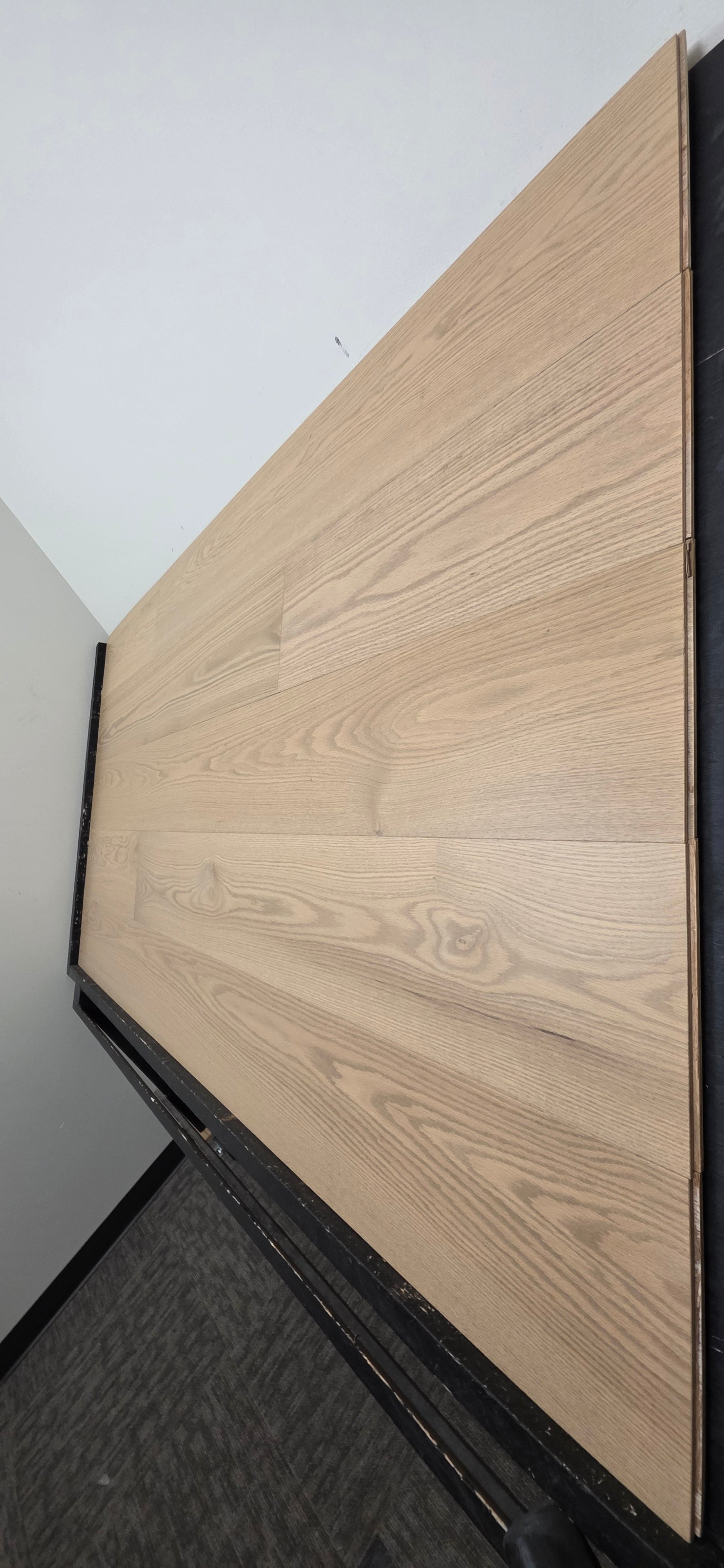 9 1/2" x 5/8" Engineered White Oak Finch Hardwood Flooring. Shown  on a black shooting table steep right angle. 