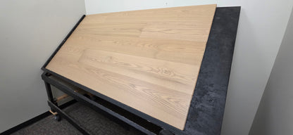 9 1/2" x 5/8" Engineered White Oak Finch Hardwood Flooring. Shown  on a black shooting table. Wide righthand shot. 