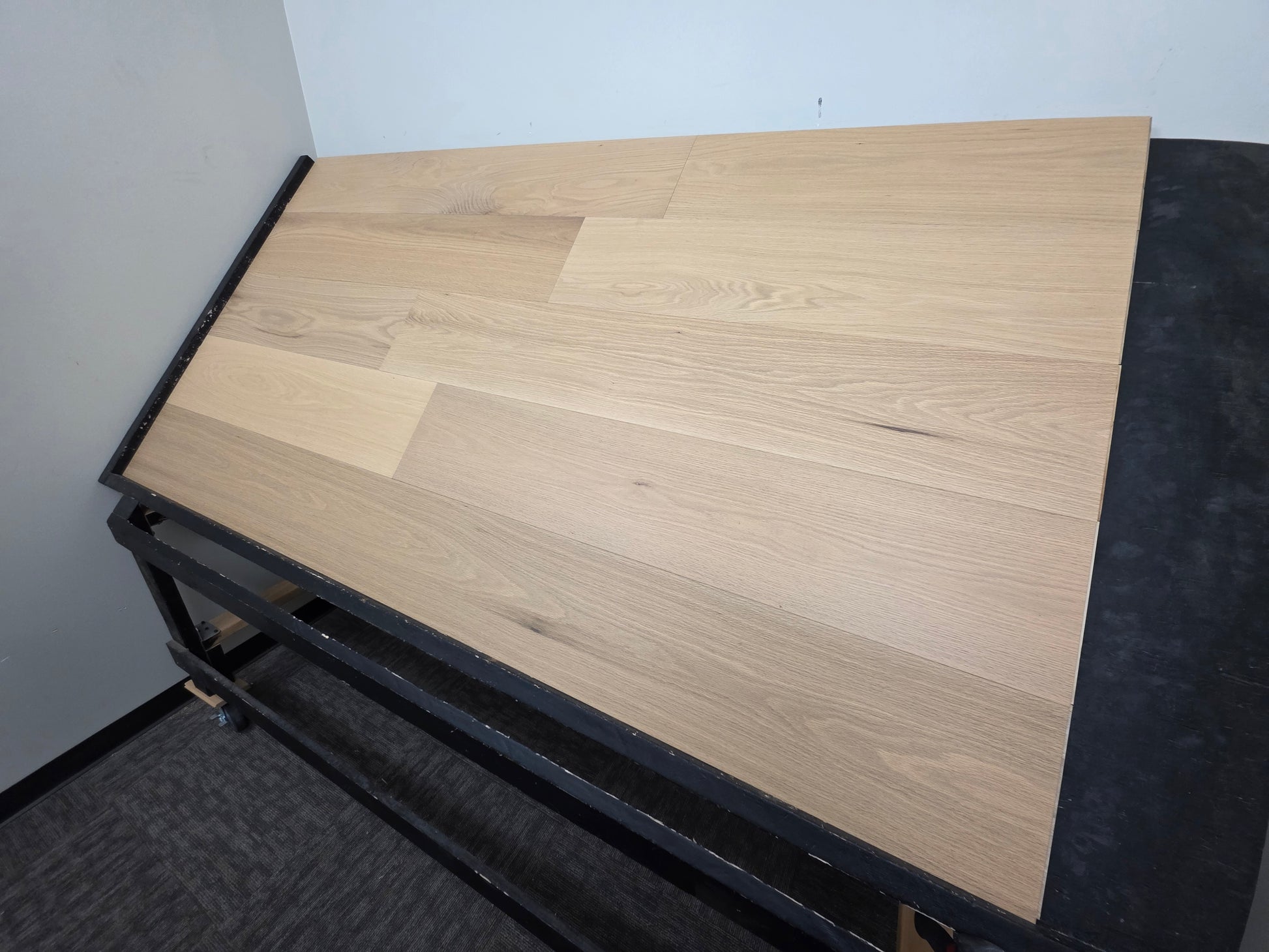 9 1/2" x 5/8" Engineered White Oak Sparrow Hardwood Flooring. Shown on a black shooting rack from the right side