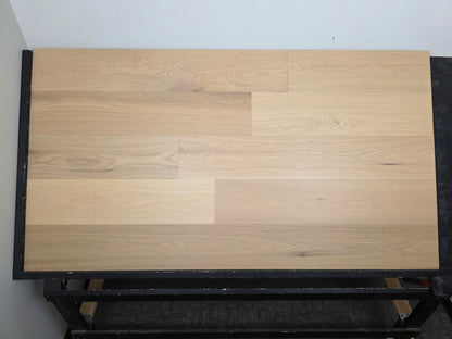 9 1/2" x 5/8" Engineered White Oak Sparrow Hardwood Flooring shown head on. Placed on a black shooting rack.