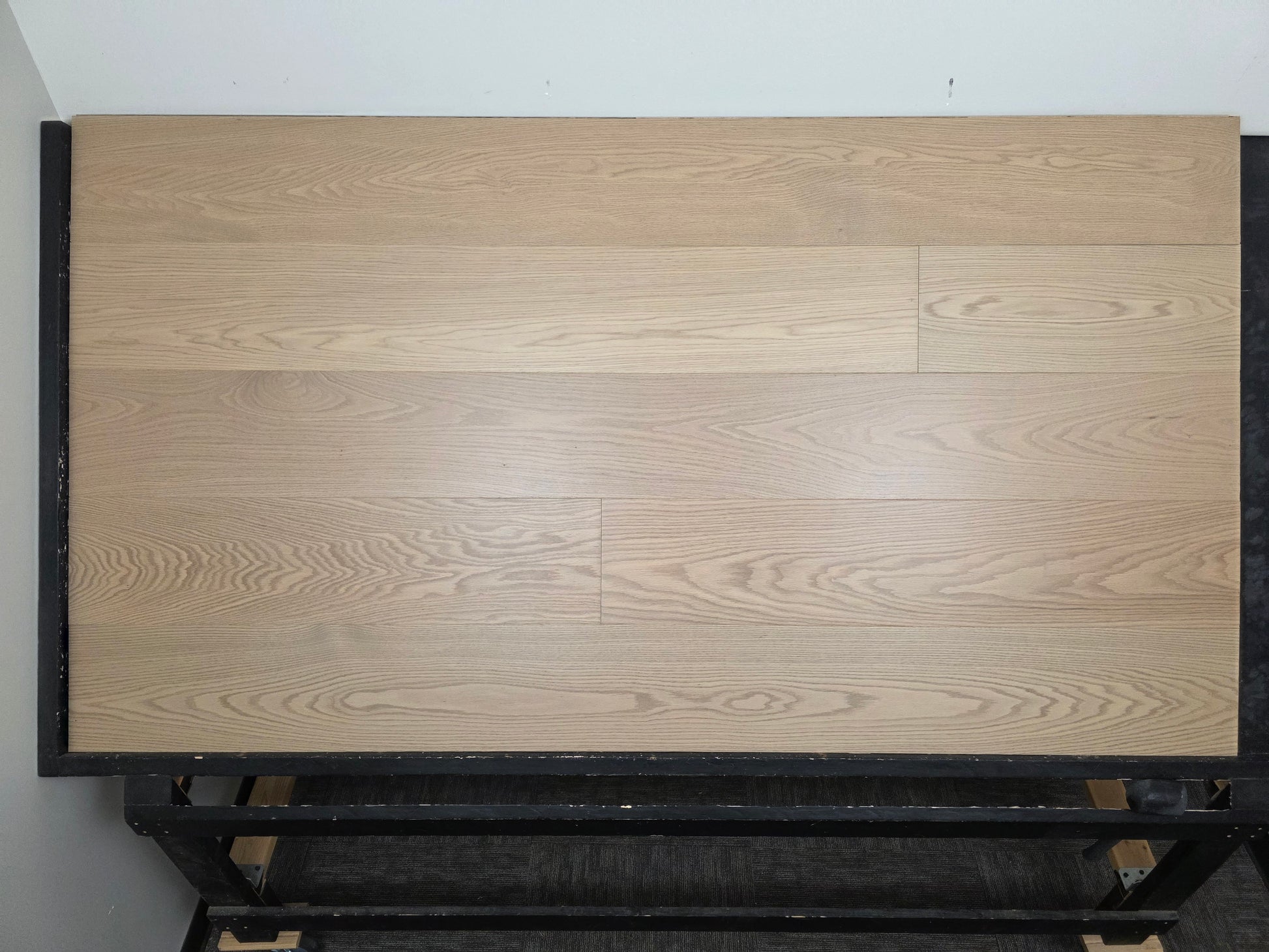 9 1/2" x 5/8" Engineered White Oak Swan Hardwood Flooring. Shown on a black shooting rack. Head on shot. 