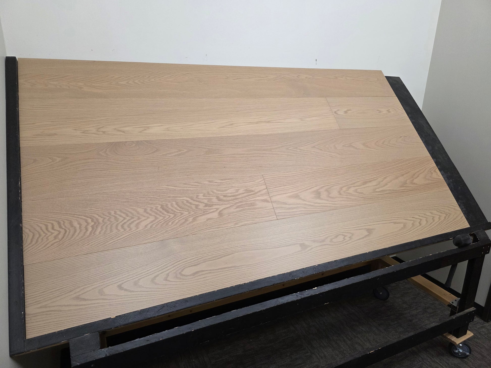 9 1/2" x 5/8" Engineered White Oak Swan Hardwood Flooring. Shown on a black shooting rack. left side shot.