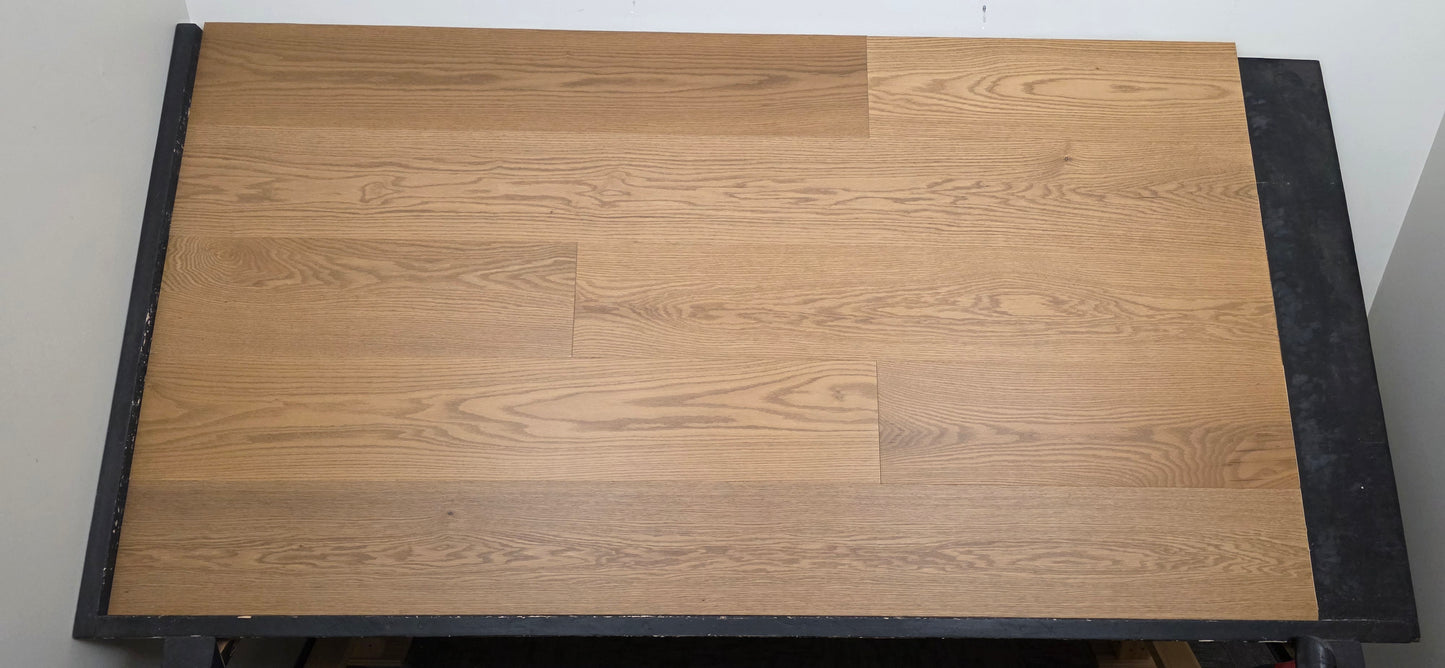 9 1/2" x 5/8" Engineered White Oak Waxwing Hardwood Flooring shown on a black shooting table. Shot from center.