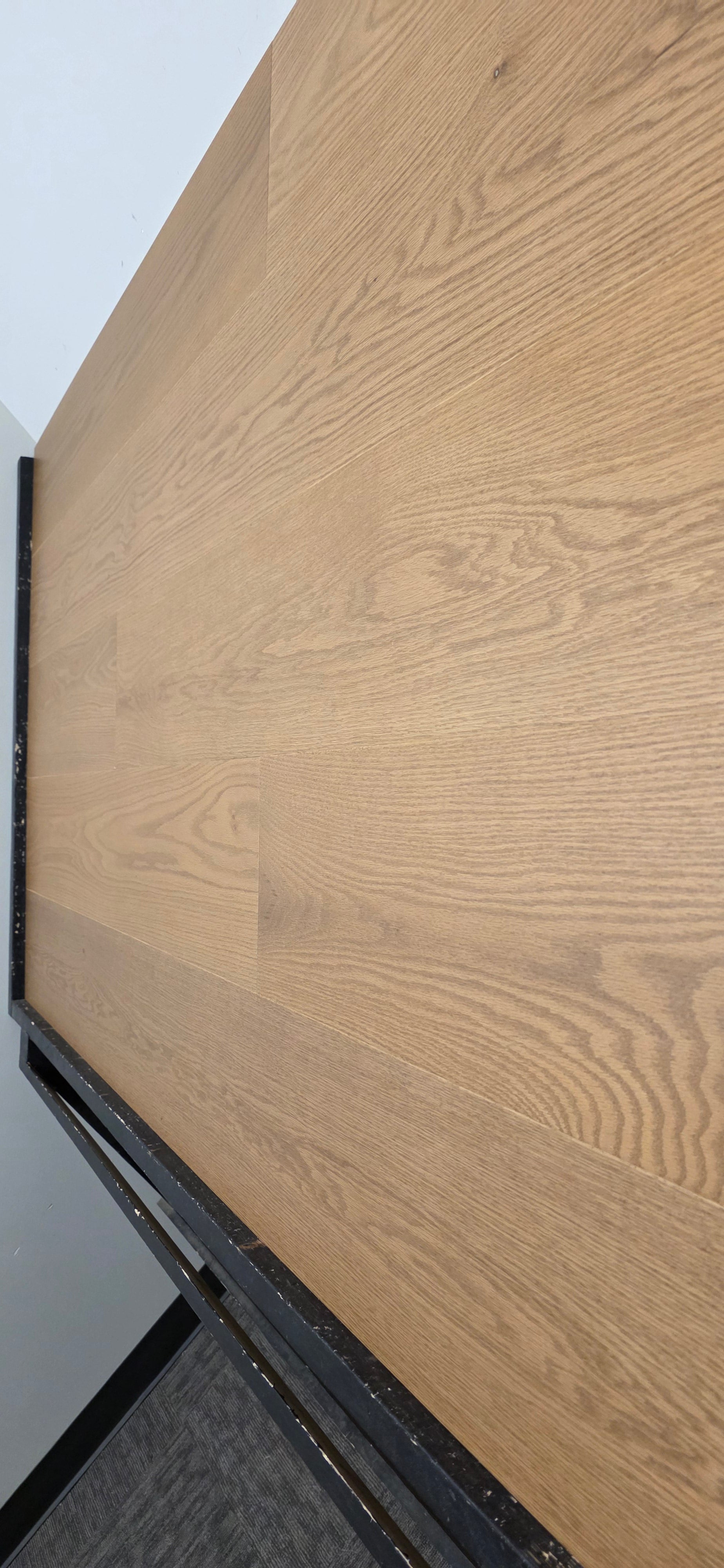 9 1/2" x 5/8" Engineered White Oak Waxwing Hardwood Flooring shown on a black shooting table. Shot from right side steep angle. 