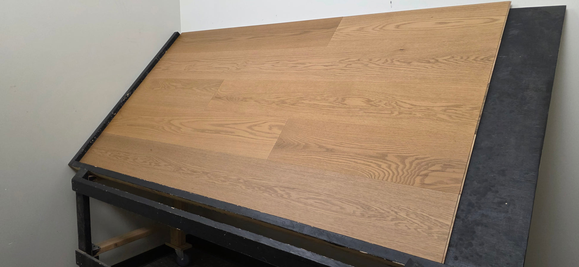 9 1/2" x 5/8" Engineered White Oak Waxwing Hardwood Flooring shown on a black shooting table. Shot from the right hand side.