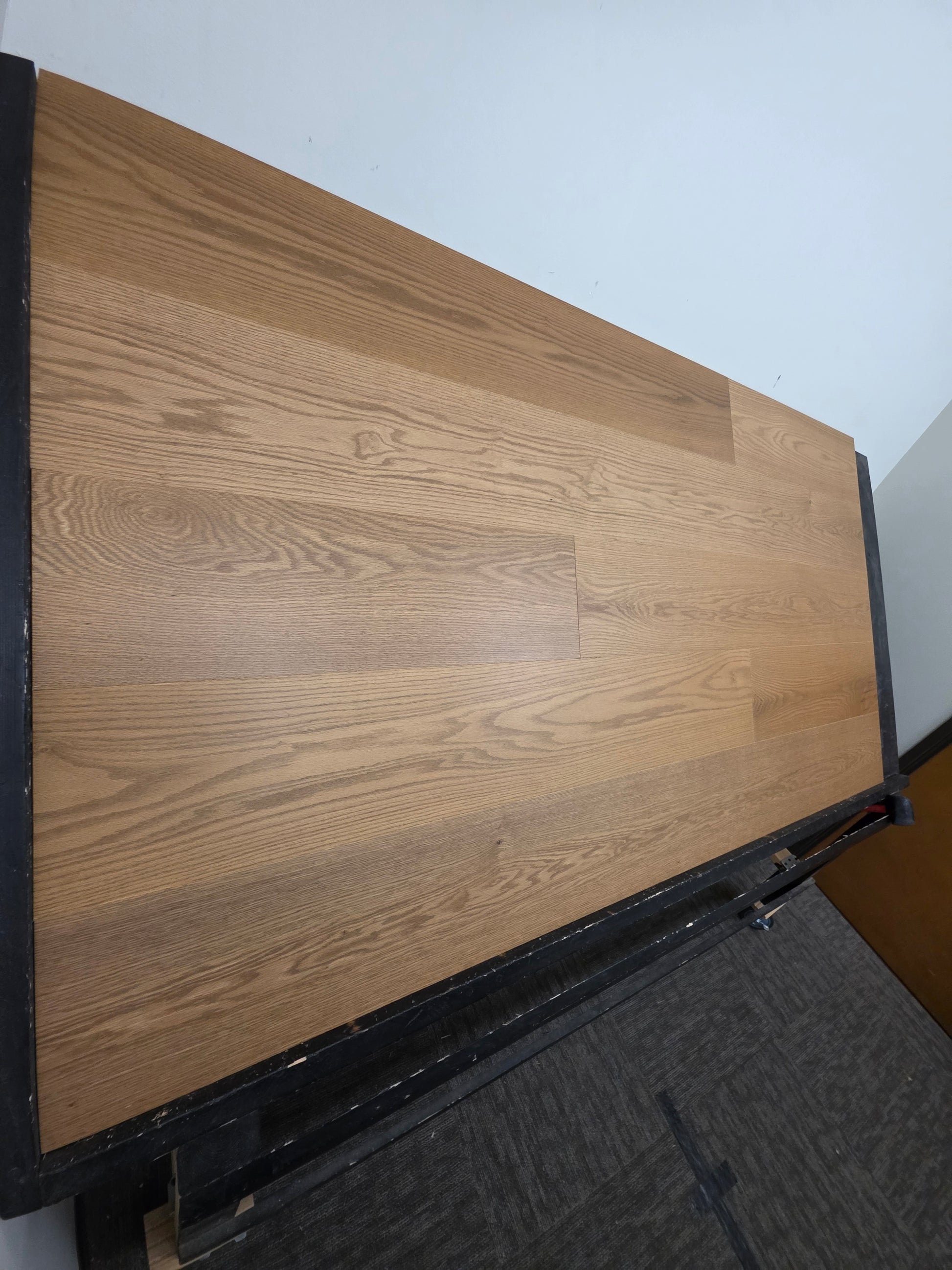 9 1/2" x 5/8" Engineered White Oak Waxwing Hardwood Flooring shown on a black shooting table. Shot from the right hand side. 