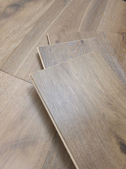 9 1/2" x 9/16" Engineered White Oak Atlas Hardwood Flooring shown stacked on top of the floor. stack is three planks high. 