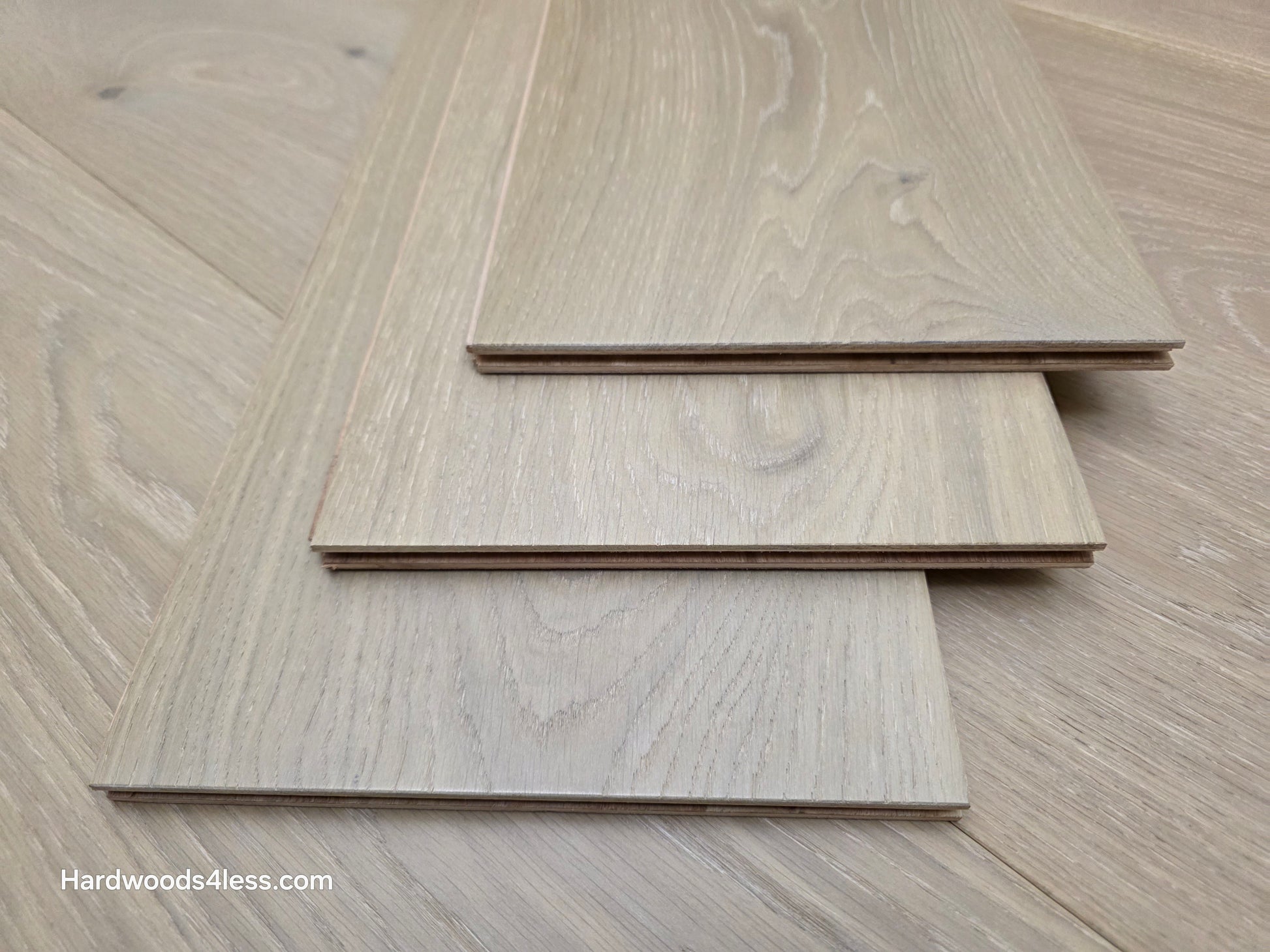 9 1/2" x 9/16" Engineered White Oak Daphne Hardwood Flooring shown as three pieces stacks atop eachother.
