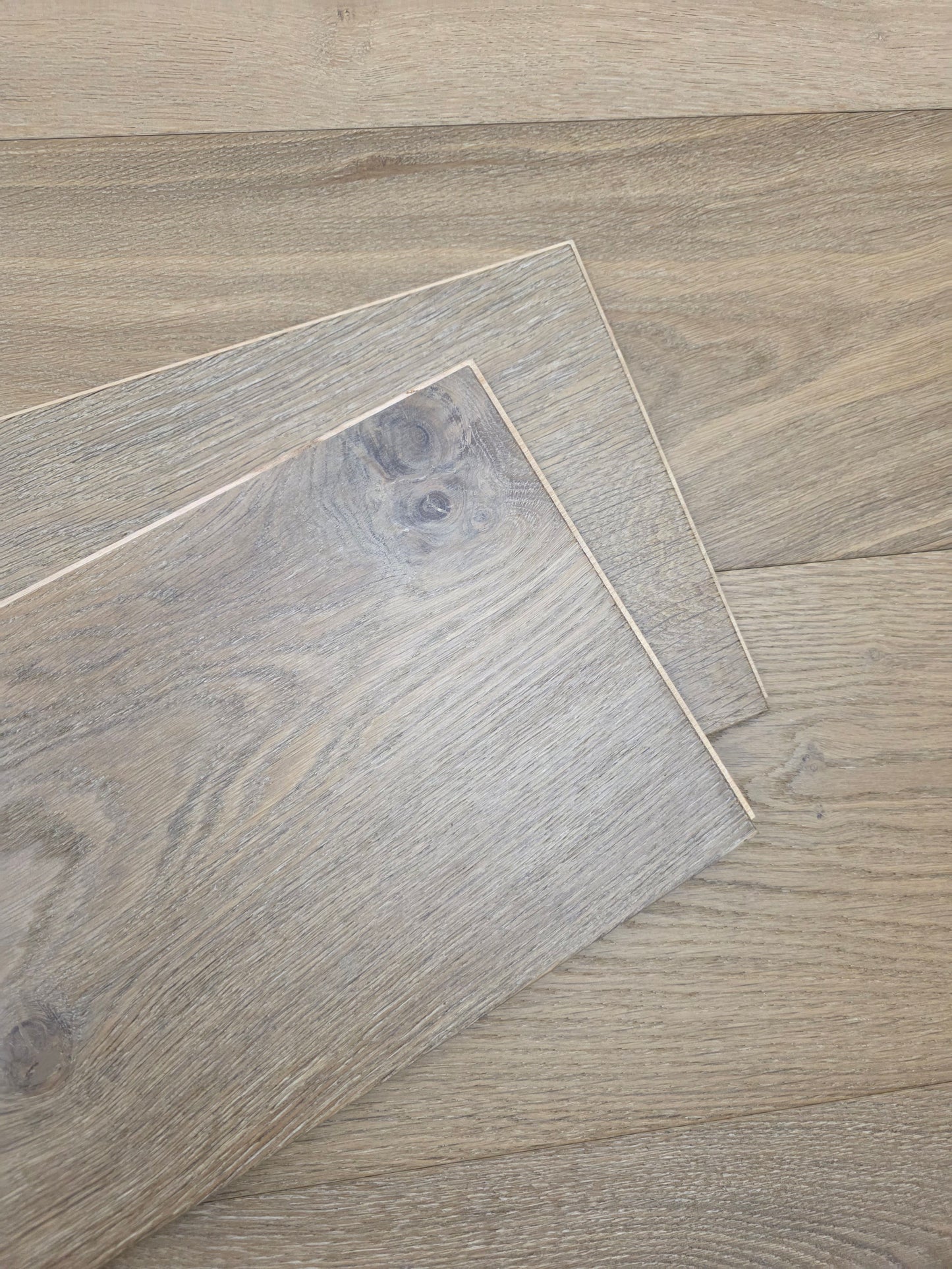 9 1/2" x 9/16" Engineered White Oak Elysian Hardwood Flooring. Shown as 2 boards stacked on the floor.