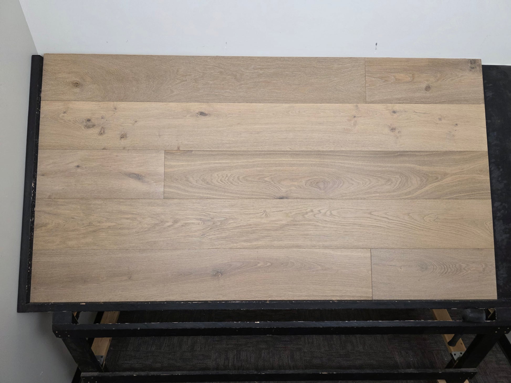 9 1/2" x 9/16" Engineered White Oak Elysian Hardwood Flooring. Shown on a black shooting table. Center shot.