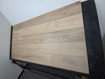 9 1/2" x 9/16" Engineered White Oak Elysian Hardwood Flooring. Shown on a black shooting table. Shot at a steep right angle.