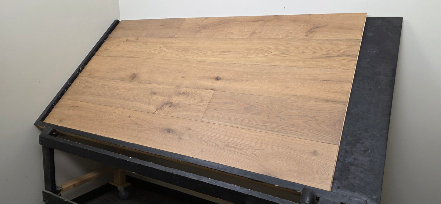 9 1/2" x 9/16" Engineered White Oak Oikos Hardwood Flooring. Shown on a black shooting table. Wide right hand shot. 