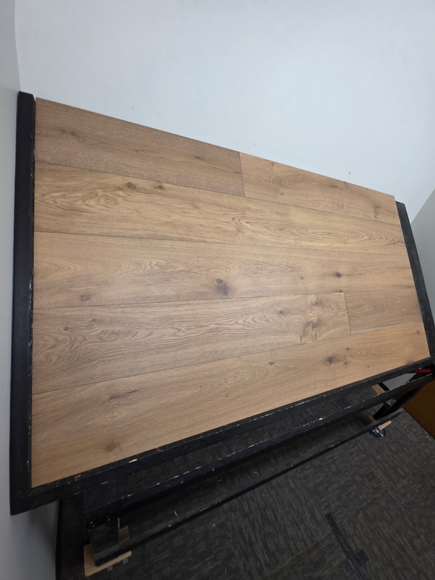 9 1/2" x 9/16" Engineered White Oak Oikos Hardwood Flooring. Shown on a black shooting table. Very wide left side shot.