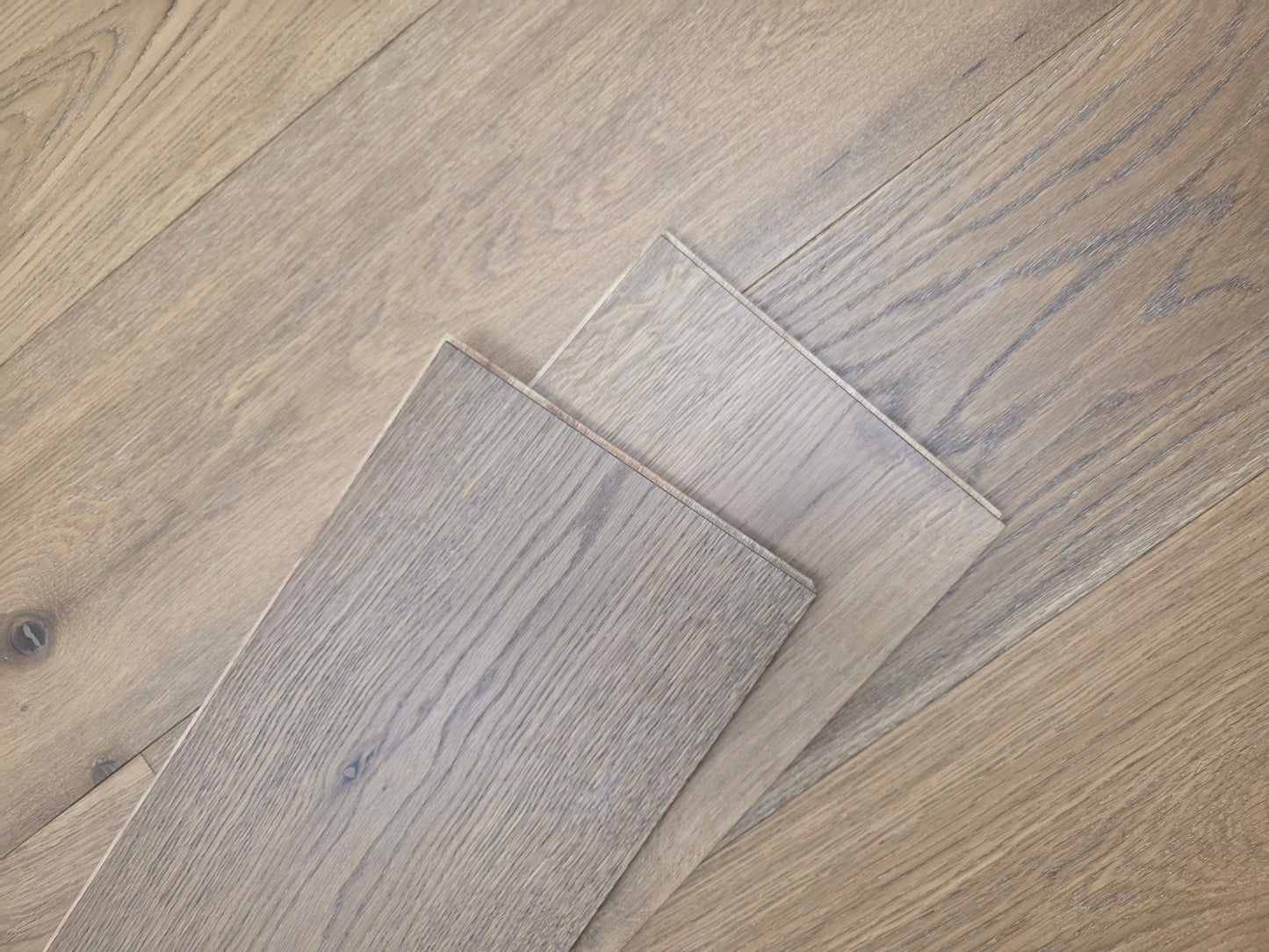 9 1/2" x 9/16" Engineered White Oak Oikos Hardwood Flooring. Shown as 2 planks stacked atop the floor.