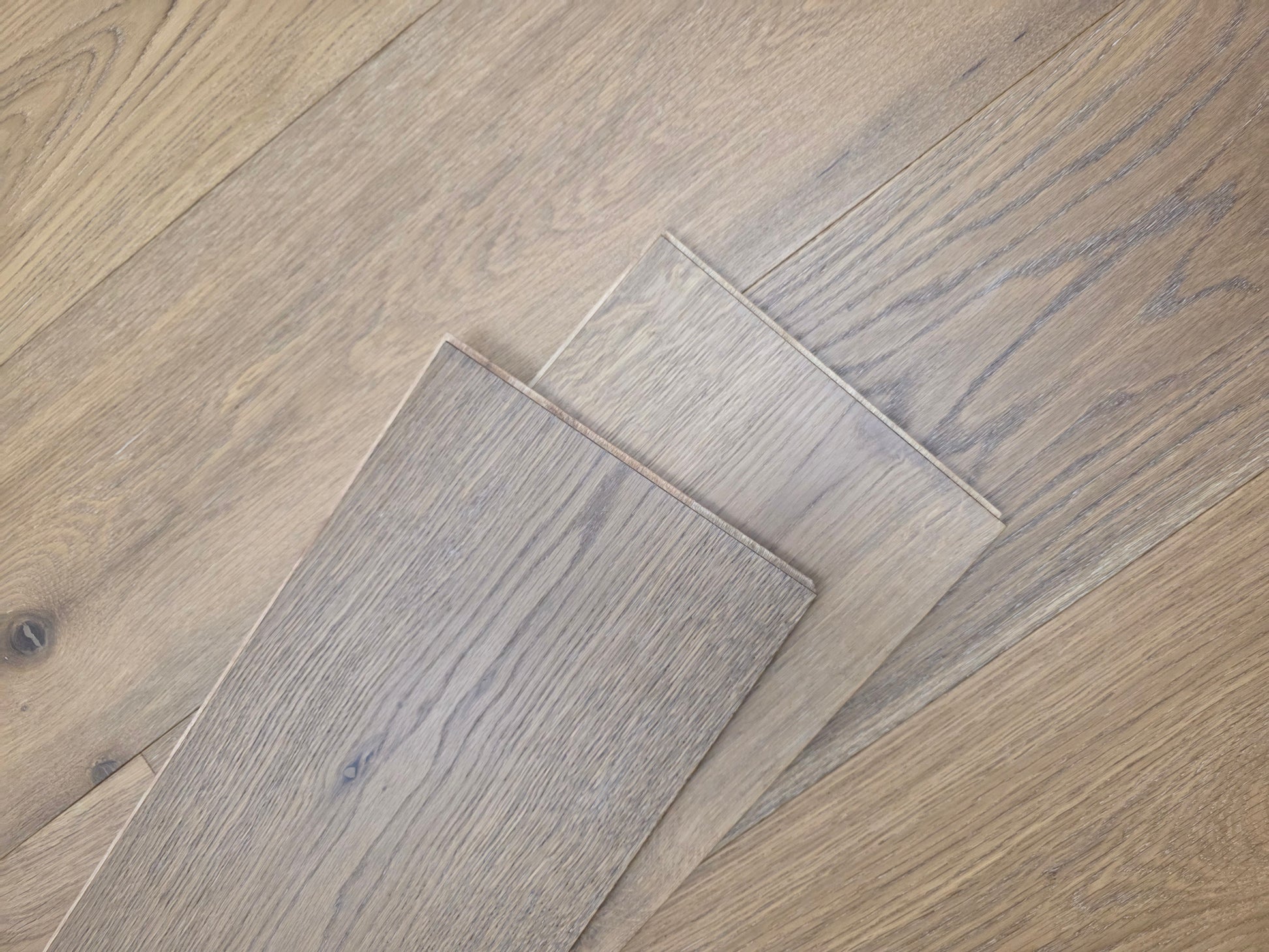 9 1/2" x 9/16" Engineered White Oak Oikos Hardwood Flooring. Shown as 2 planks stacked atop the floor.