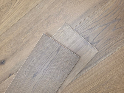 9 1/2" x 9/16" Engineered White Oak Oikos Hardwood Flooring. Shown as 2 planks stacked atop the floor.
