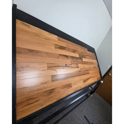 3 1/4" x 3/4" Solid Prefinished Tigerwood Hardwood Flooring. Shot from steep left. Shown on a black shooting table. 