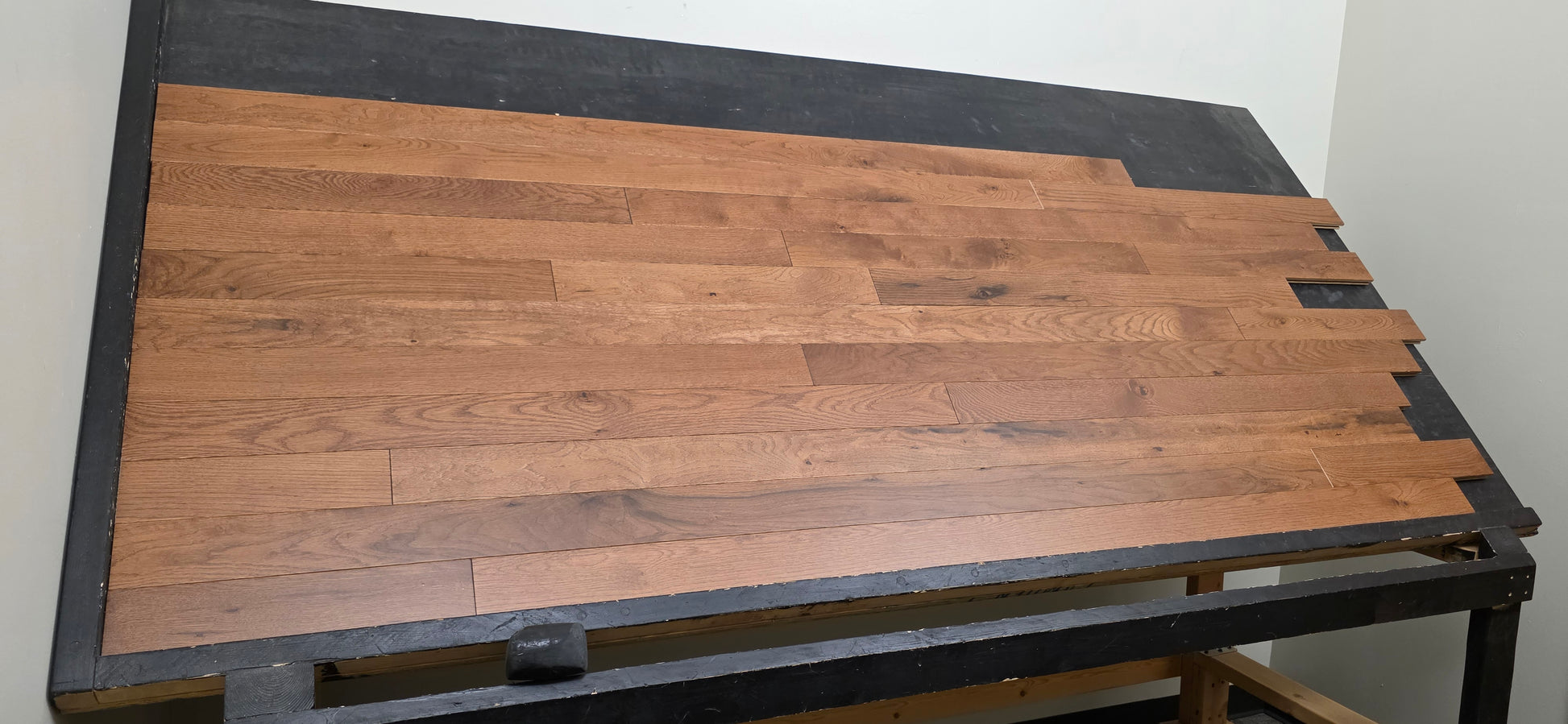 left angle shot of Red Oak Gunstock Character Grade Hardwood Flooring on a black table