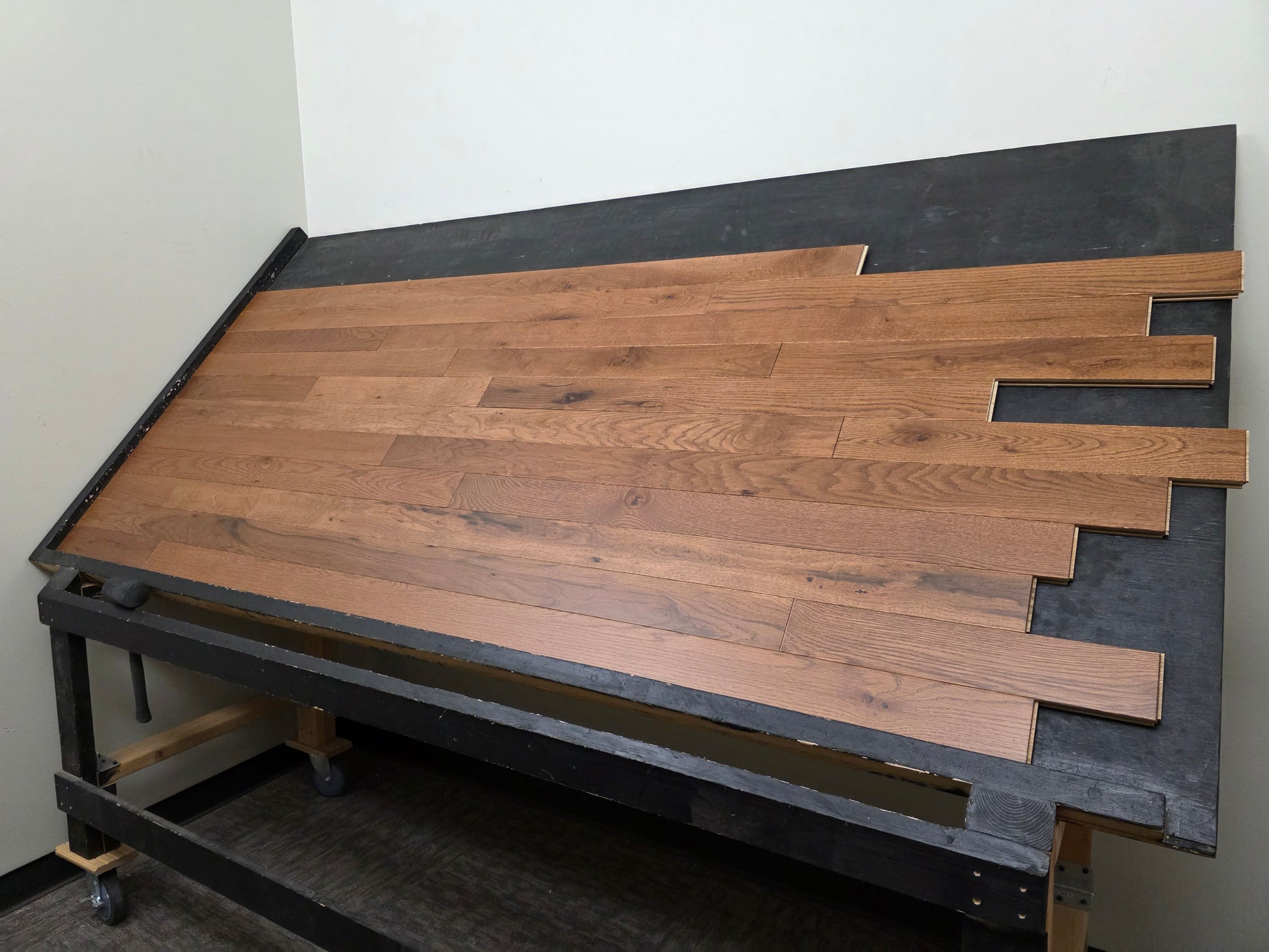 Table shot of Red Oak Gunstock Character Grade Hardwood Flooring on a black table. Right angle shot