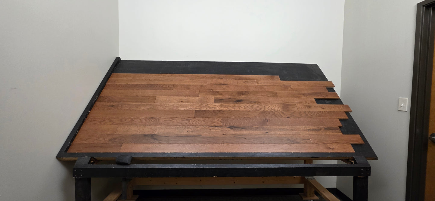 Table shot of Red Oak Gunstock Character Grade Hardwood Flooring on a black table 