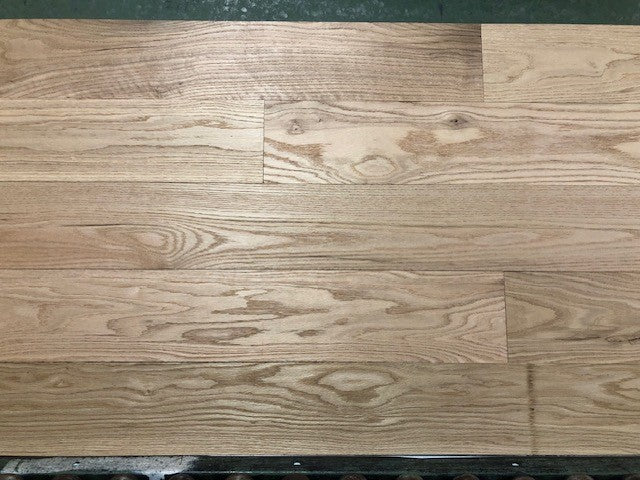 Unfinished Red Oak #1 Common Solid Hardwood Flooring. Shown on a green racking table. 
