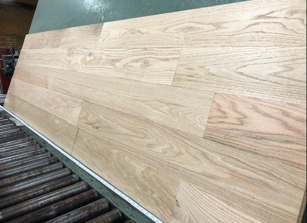 Unfinished Red Oak #1 Common Solid Hardwood Flooring. Shown on a green shooting rack hard right angle.