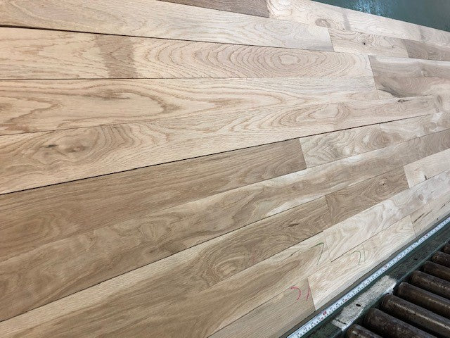 Unfinished White Oak #1 Common Solid Hardwood Flooring. Closeup on a green shooting table. 